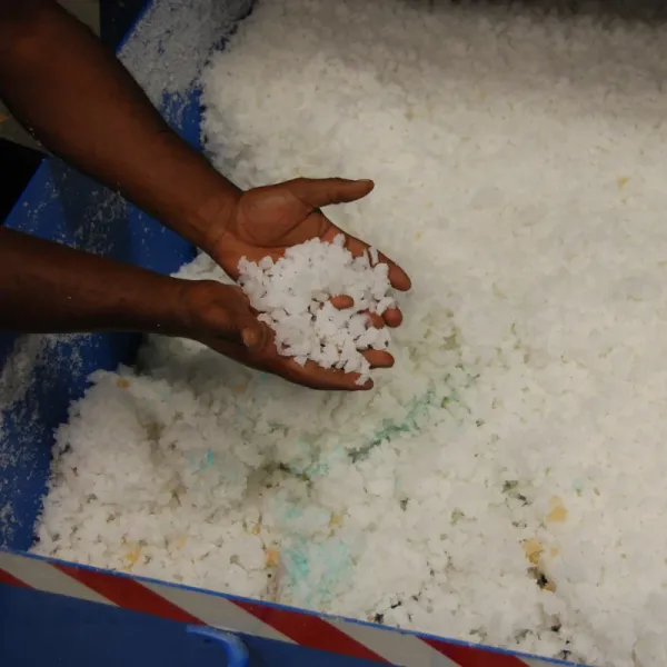 Two hands holding shredded rubber pieces