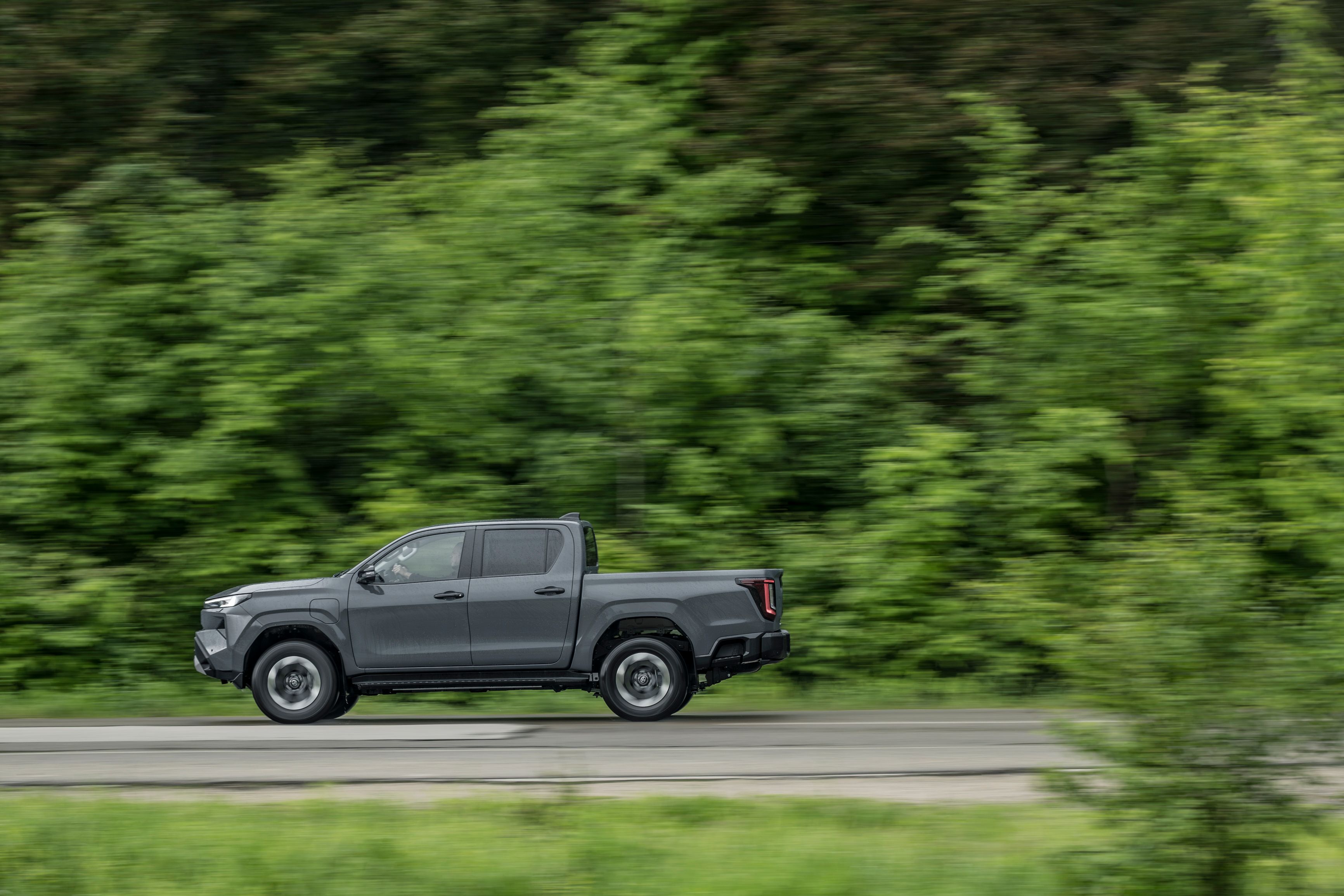 Toyota Hilux set fra siden, mens den kører på skovvej