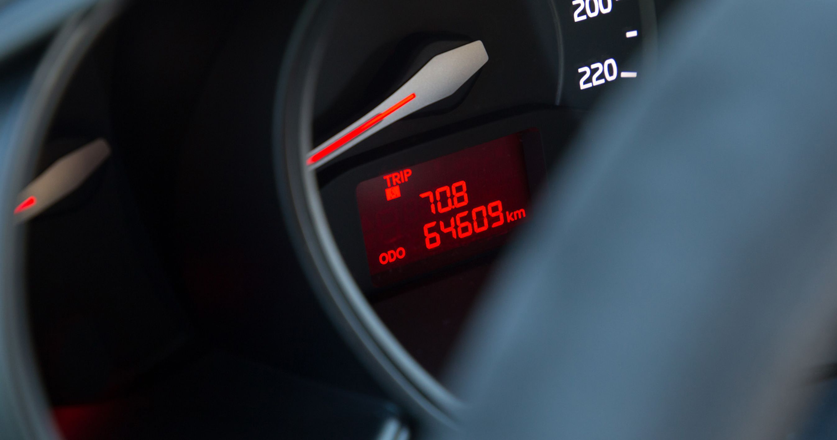 Røde kilometertal vises i et instrumenthus på en bil. 