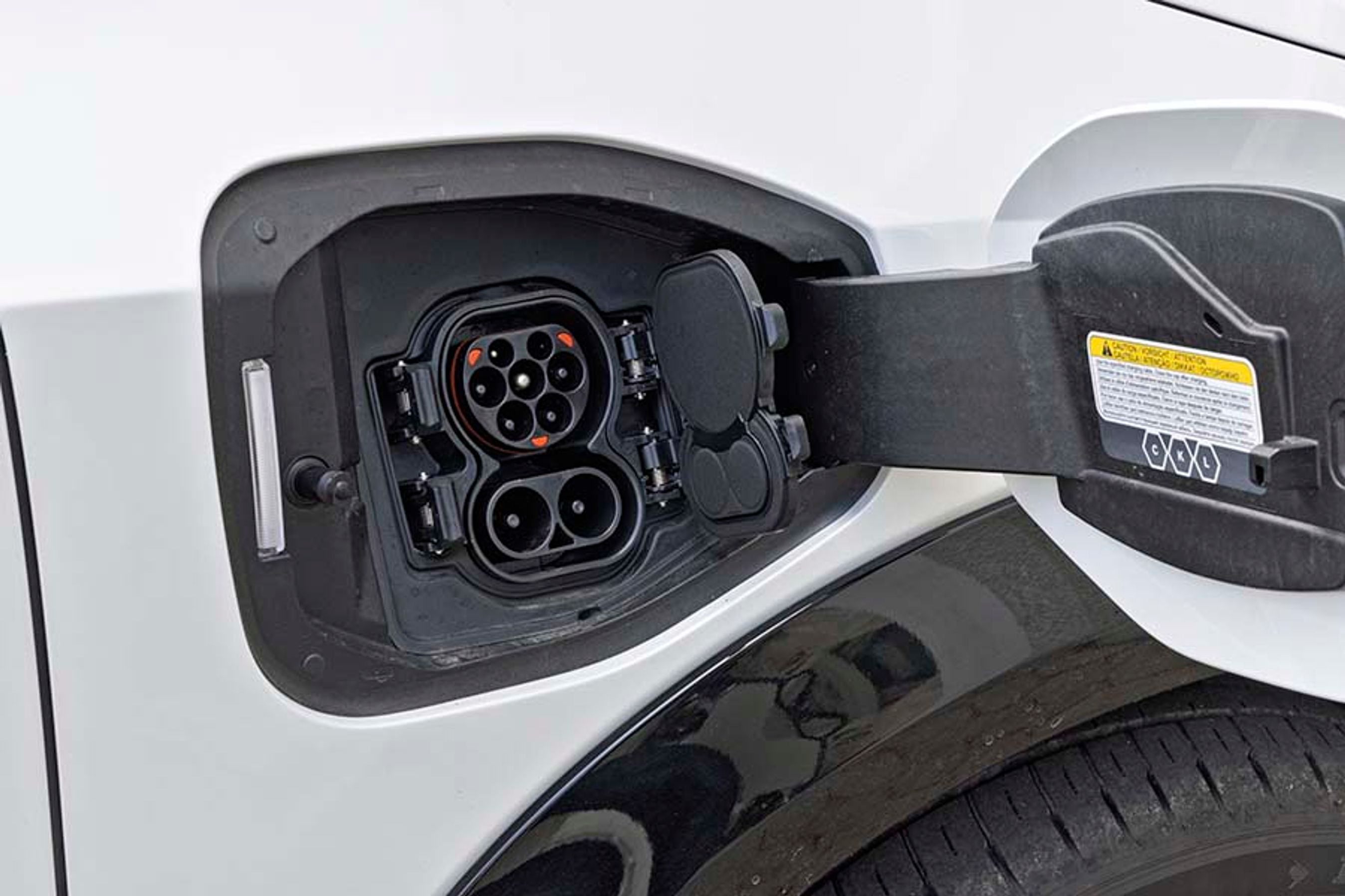 Ladelugen er placeret ved højre forhjul, og den indbyggede lader giver mulighed for at AC-lade med op til 22 kW og DC-lade på farten med op til 130 kW. To dæksler vipper fint ud, blot man trykker på en knap på dækslet.