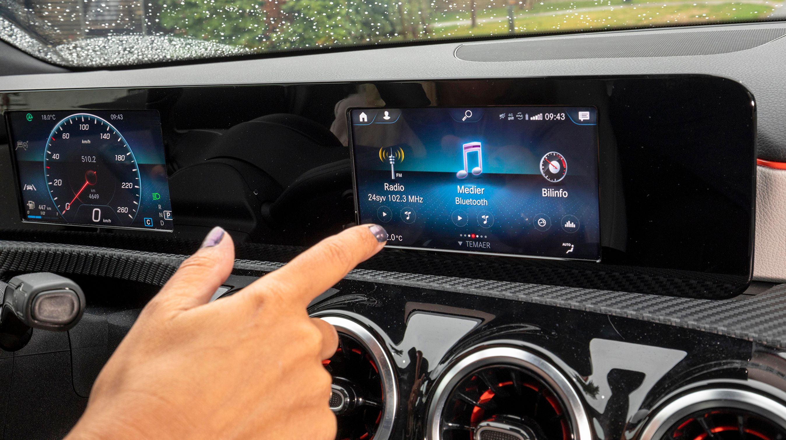 Skærmen kan betjenes ved hjælp af fingertryk, fra rattets knapper eller fra den store touchpad mellem forsæderne.