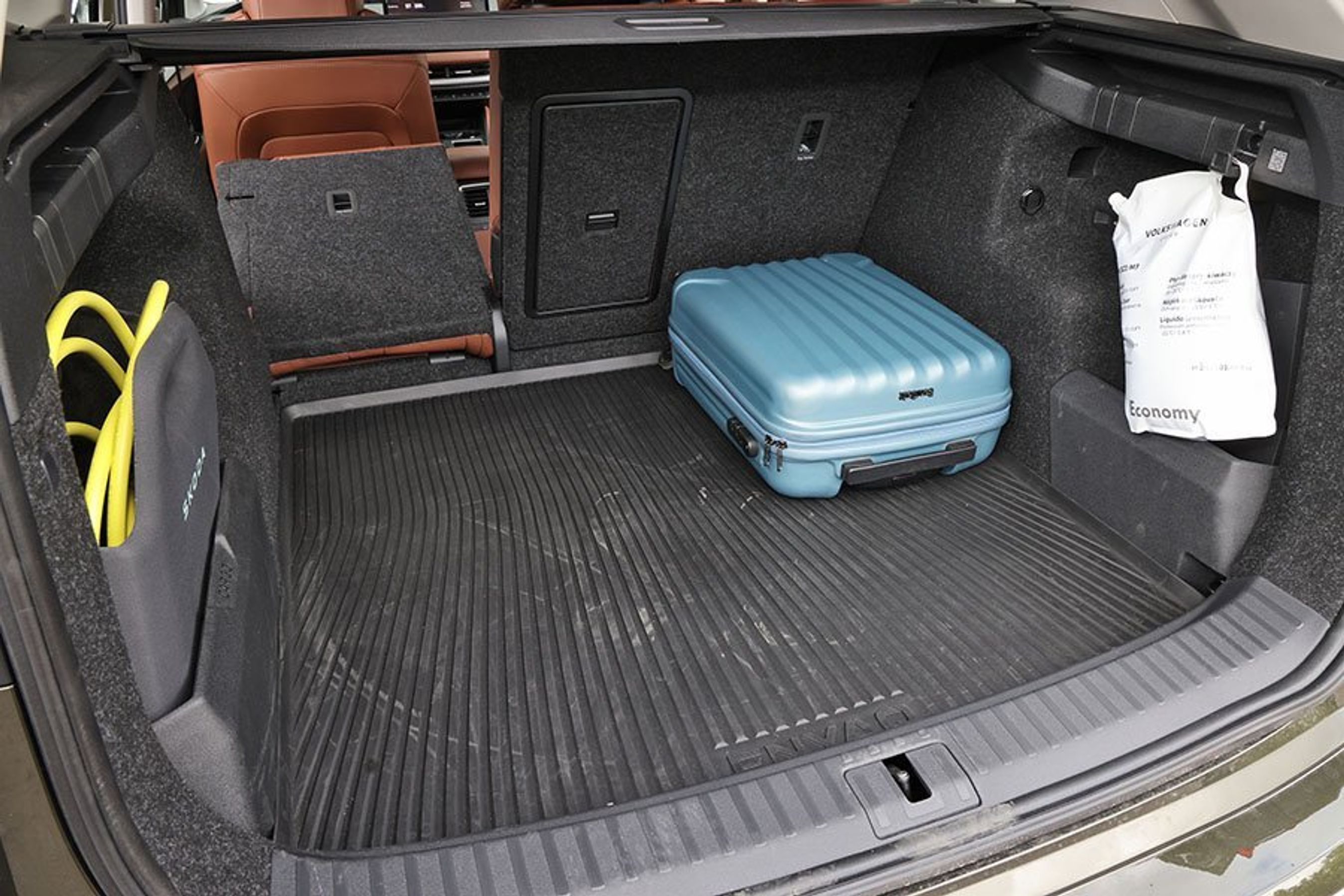 Bagagerum med blå kuffert og ladekabler i en Skoda Enyaq