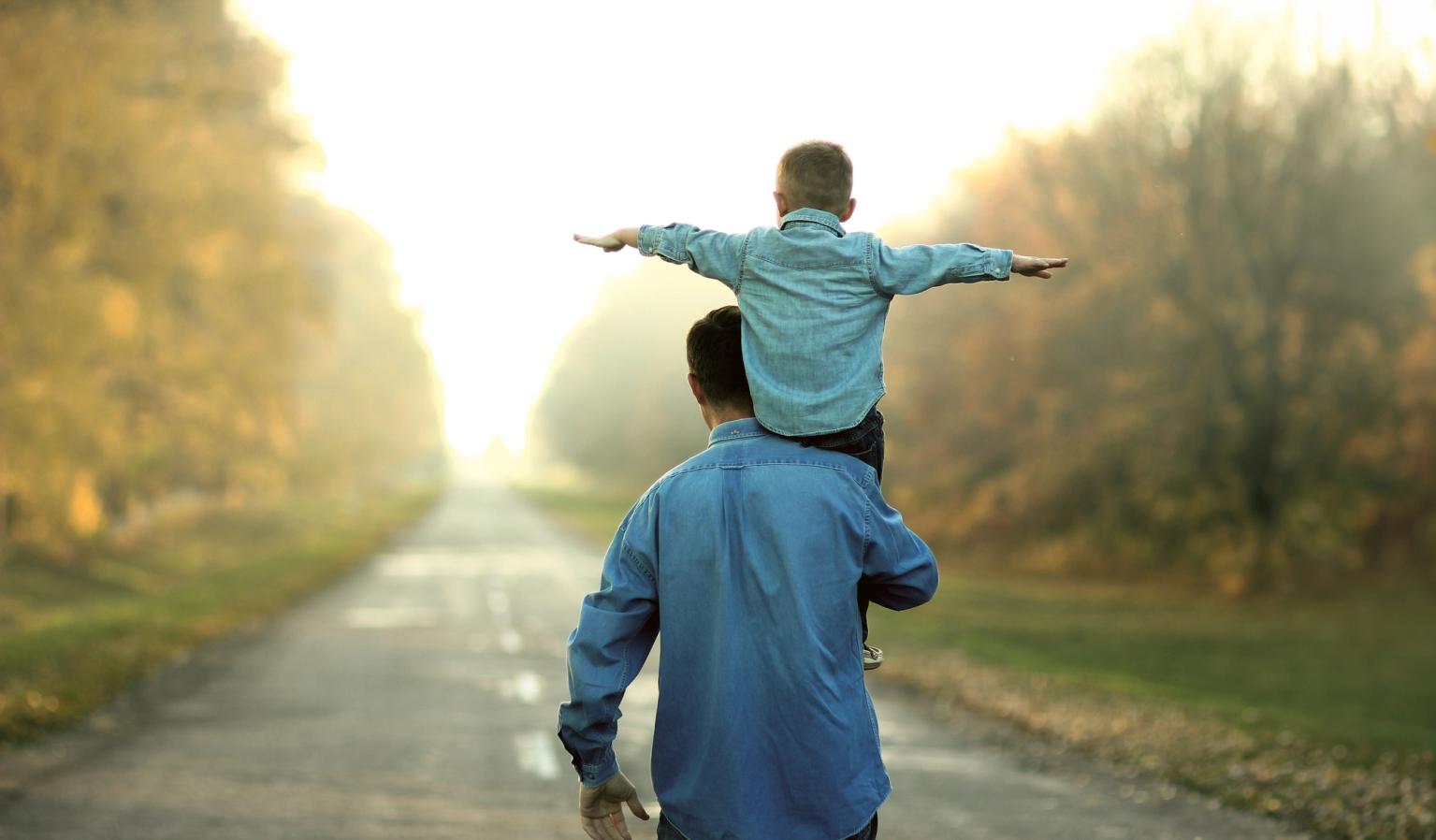 Far går med barn på skuldrene