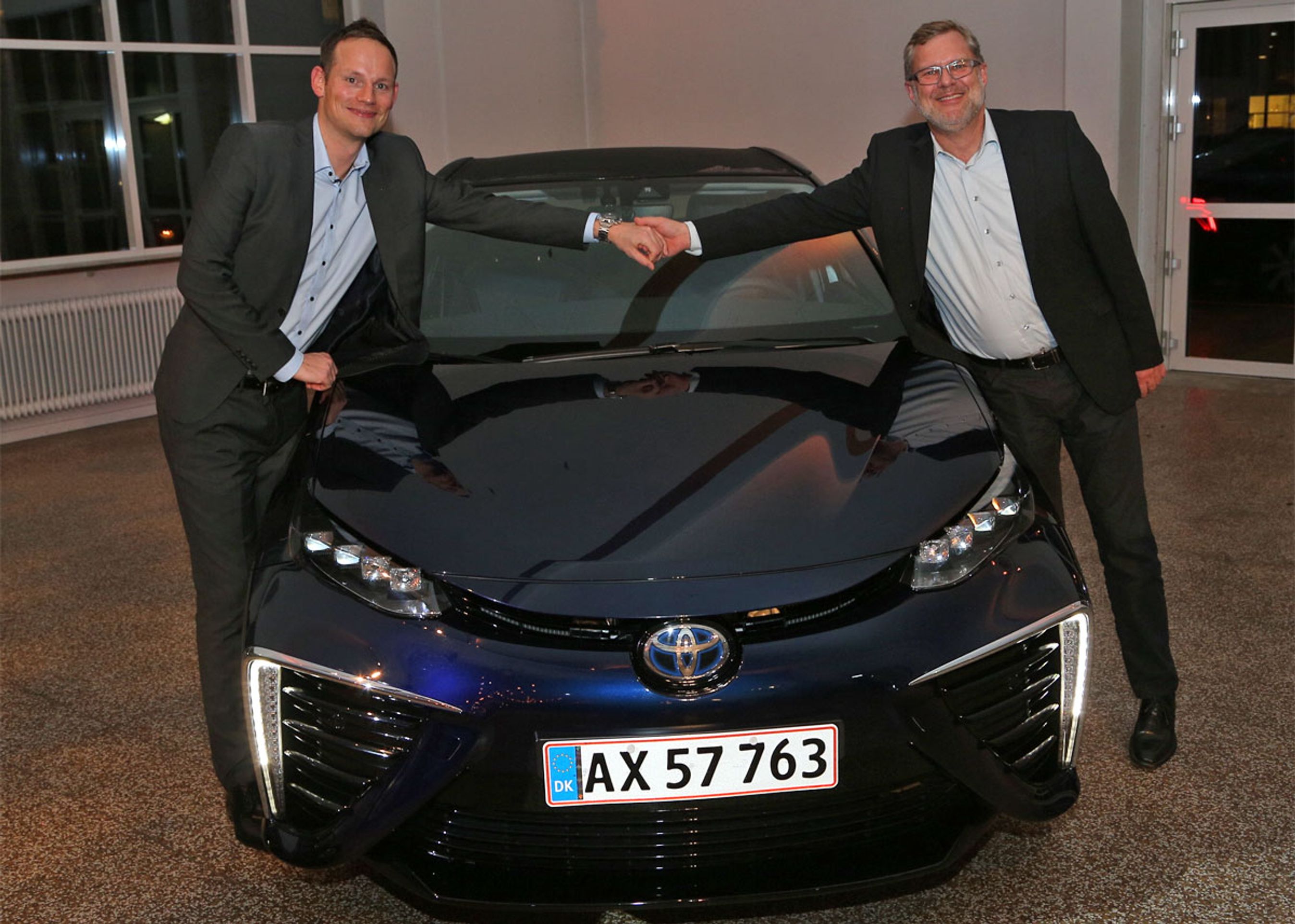 Toyota Danmarks informationschef, Anders Tystrup (t.h.) lykønskes med Mirais ærespris af formanden for Motorjournalisternes Klub Danmark, Mikkel Thomsager. Foto: Karsten M. Lemche