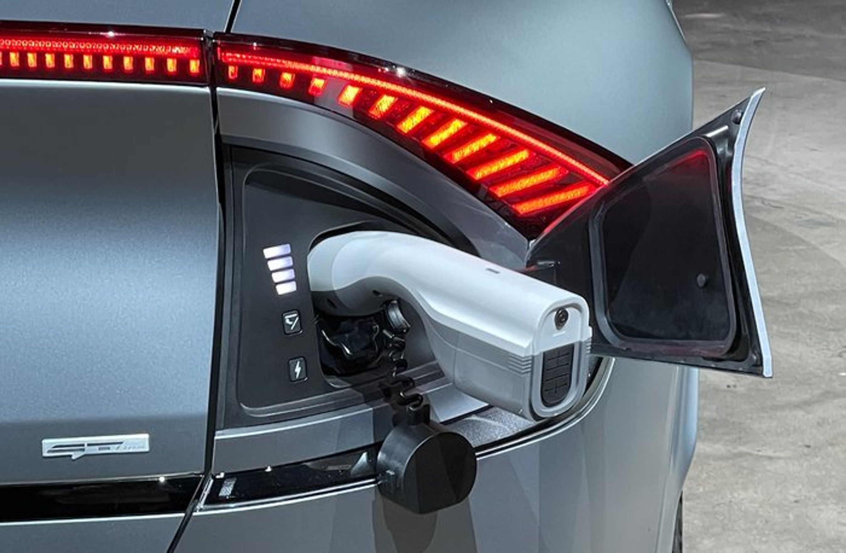 Ladeporten, som sidder i højre bagskærm, kan bruges til at trække strøm ud af bilen. Det sker med denne medfølgende adapter. Det er standard på versioner med stort batteri.