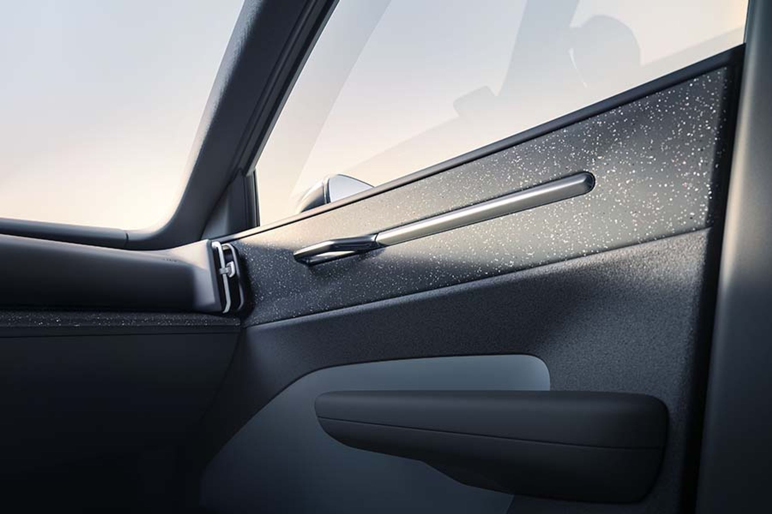 Materialet i dørsiderne og langs instrumentbordet er af genbrugsplast, og det har en noget atypisk glat overflade med mange små prikker fra genbrugsmaterialerne.