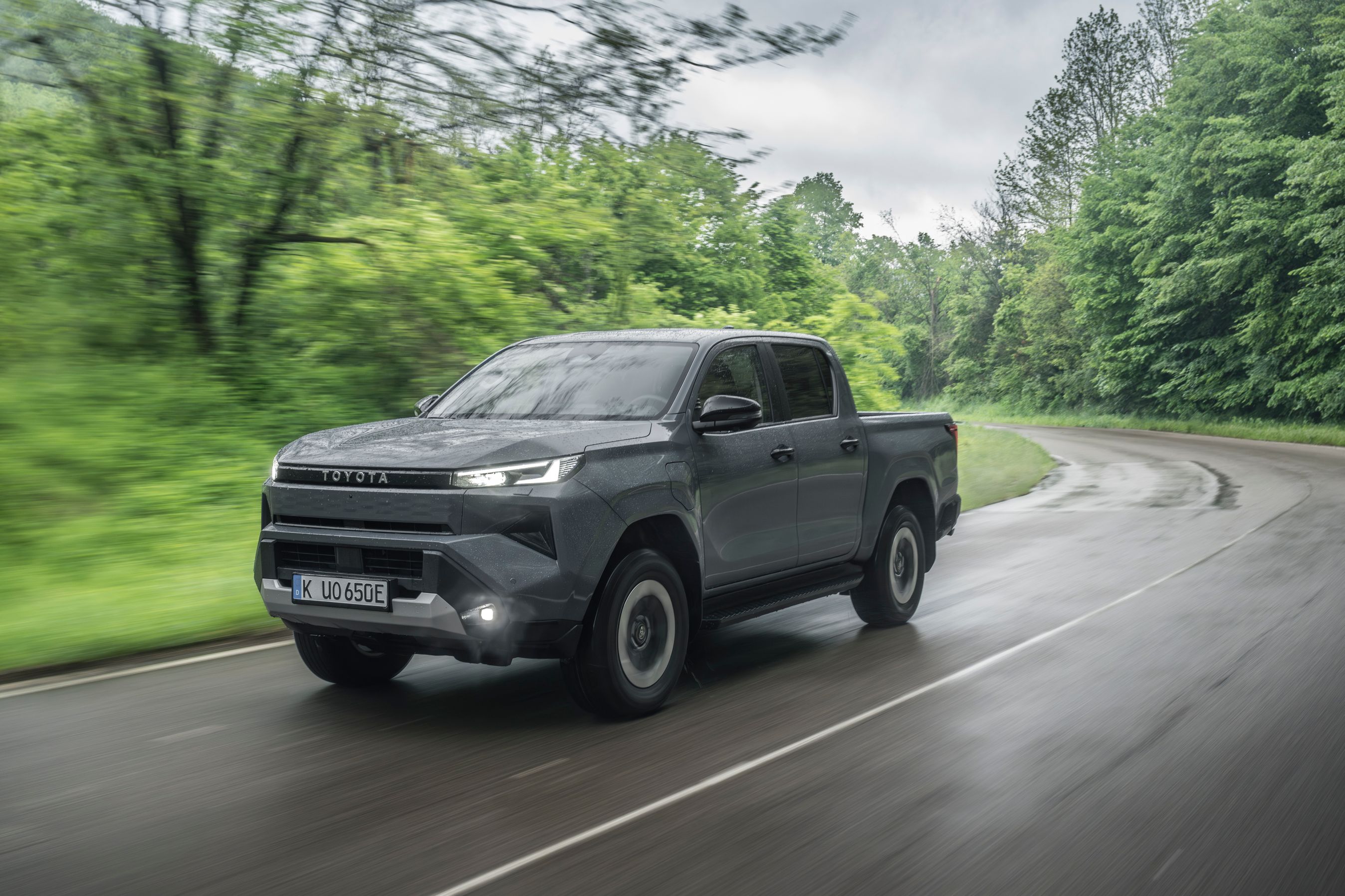 Toyota Hilux set skråt forfra, mens den kører på regnvåd vej