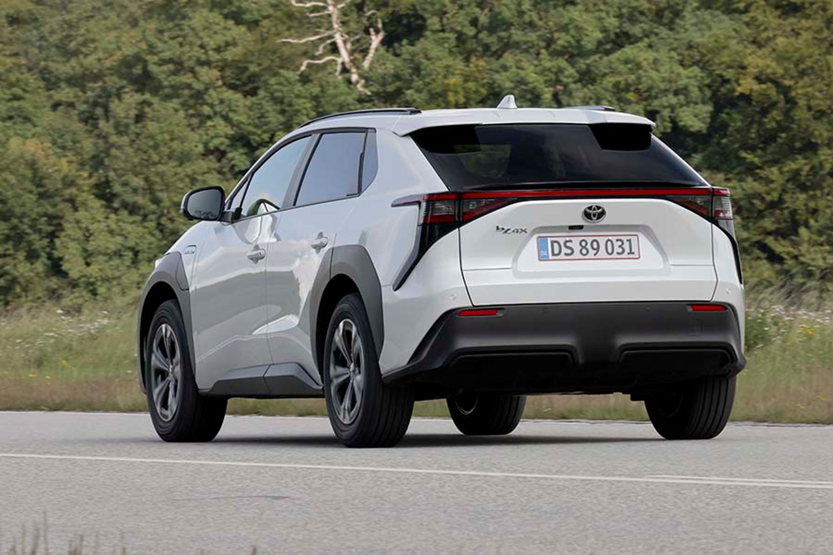 Elbilen Toyota bZ4X set bagfra, mens den kører på landevej