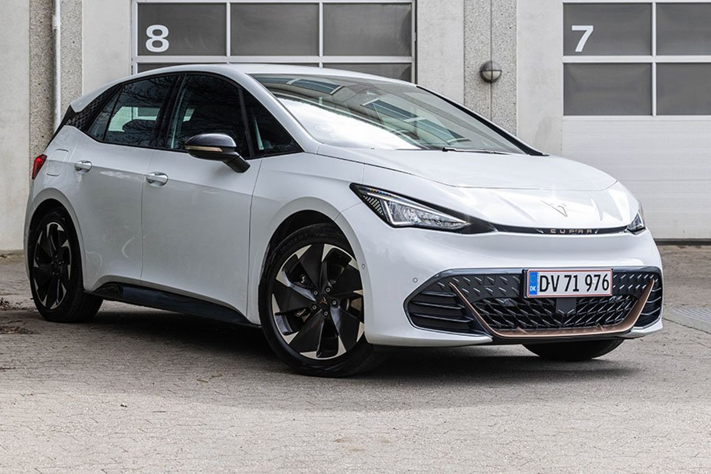 Hvid Cupra Born foran værksted