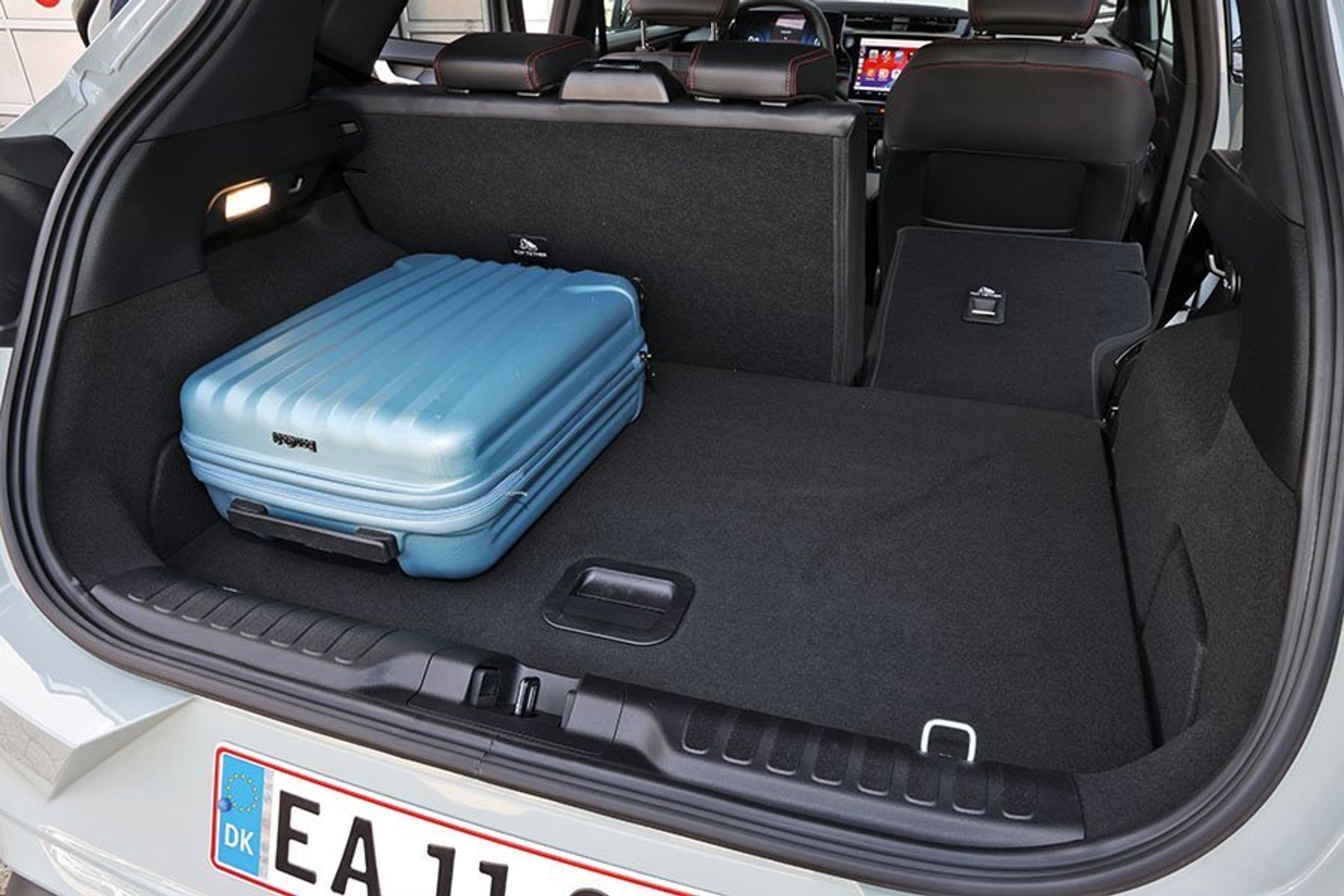 Bagagerum med blå kuffert i en Ford Puma