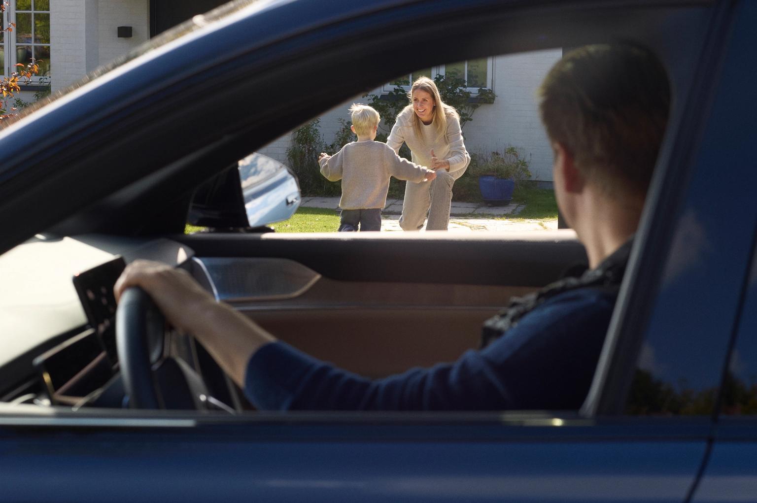 en dreng løber mod hans mor som står foran huset