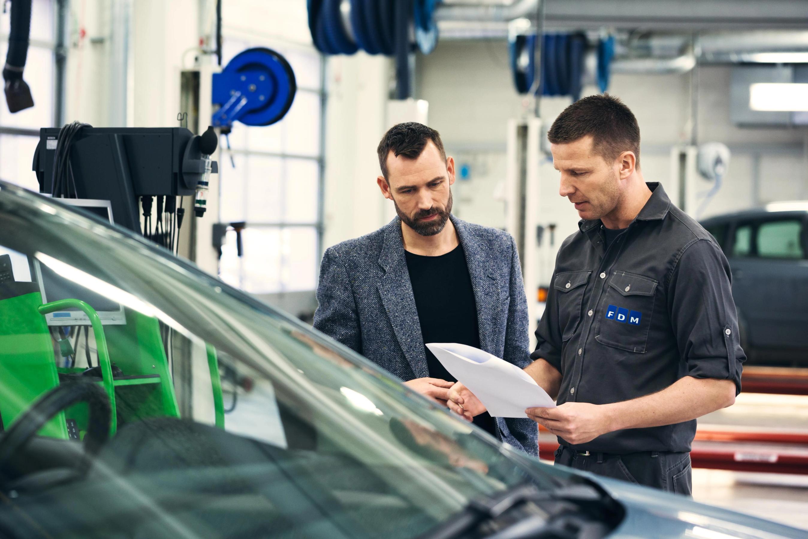 To mænd taler sammen på et værksted. 