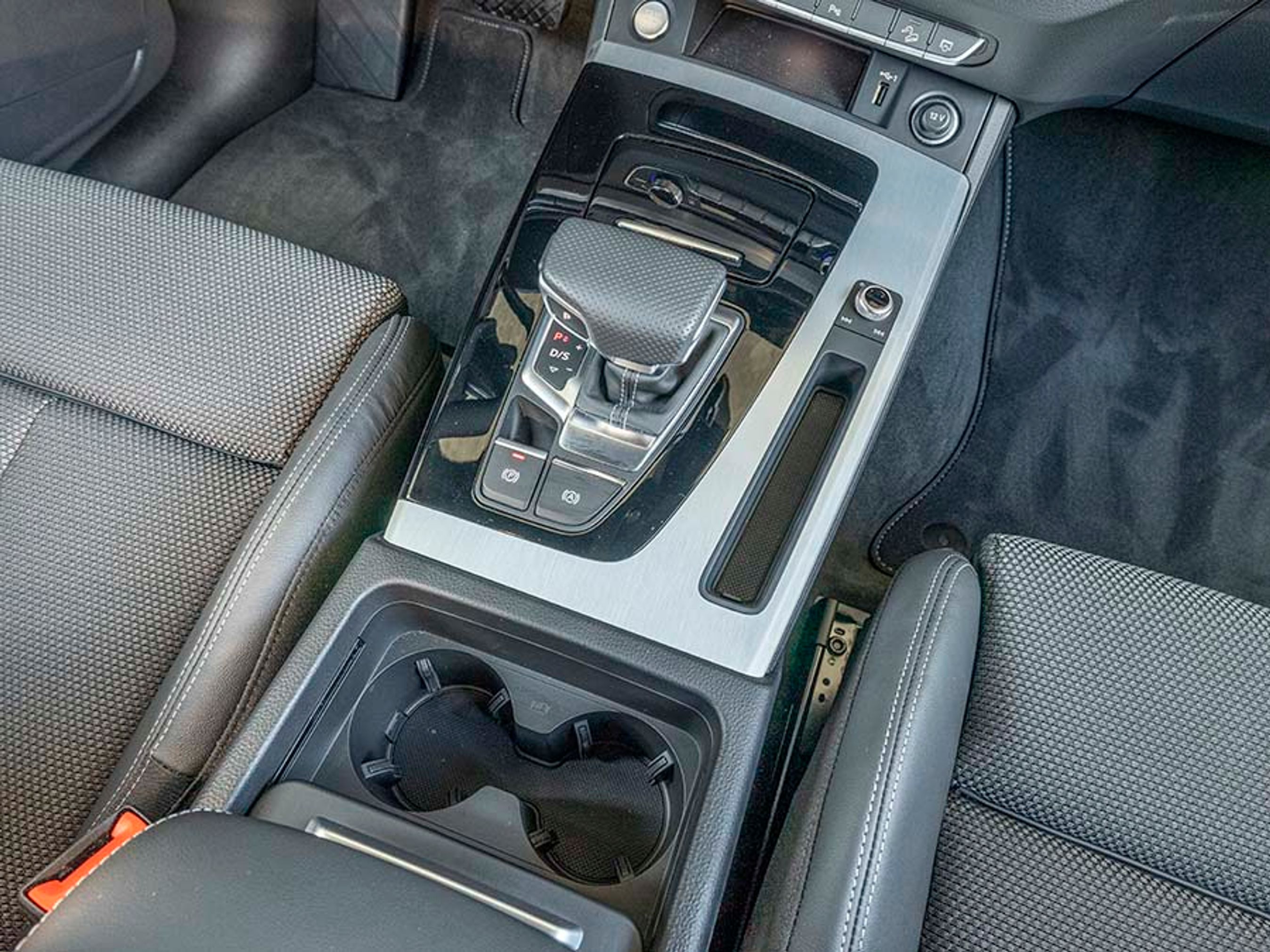 Gearvælgeren er af den elektroniske type, der selv går i P, når motoren slukkes. Der er kopholdere, men ellers ikke mange fralægningsrum, og det er et minus.