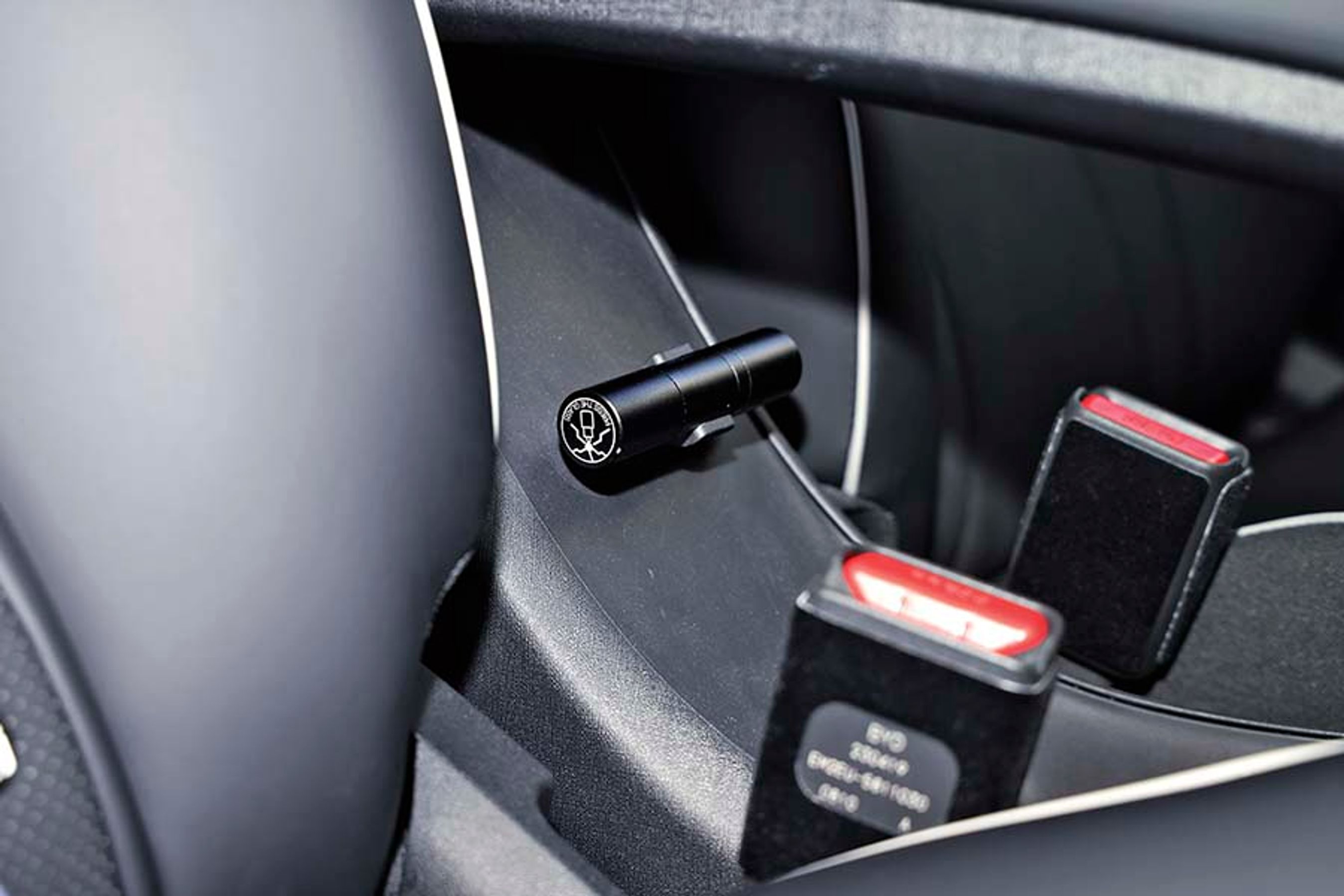 Mellem forsæderne er der et fint midterarmlæn, og under det er denne kniv monteret. Den kan bruges til at skære sikkerhedsselerne over i en kritisk situation.