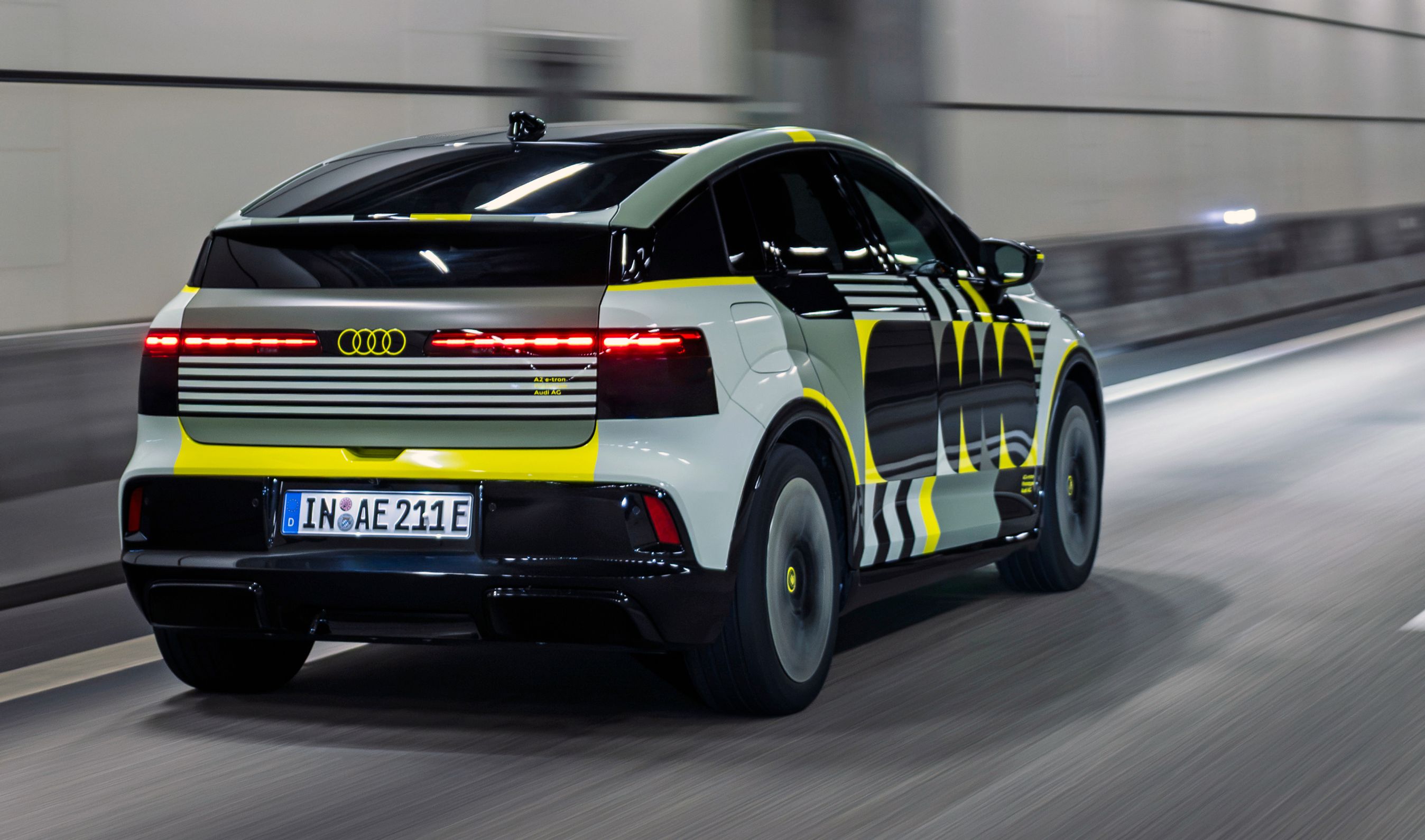 Kamufleret Audi A2 skråt bagfra kørende i tunnel.