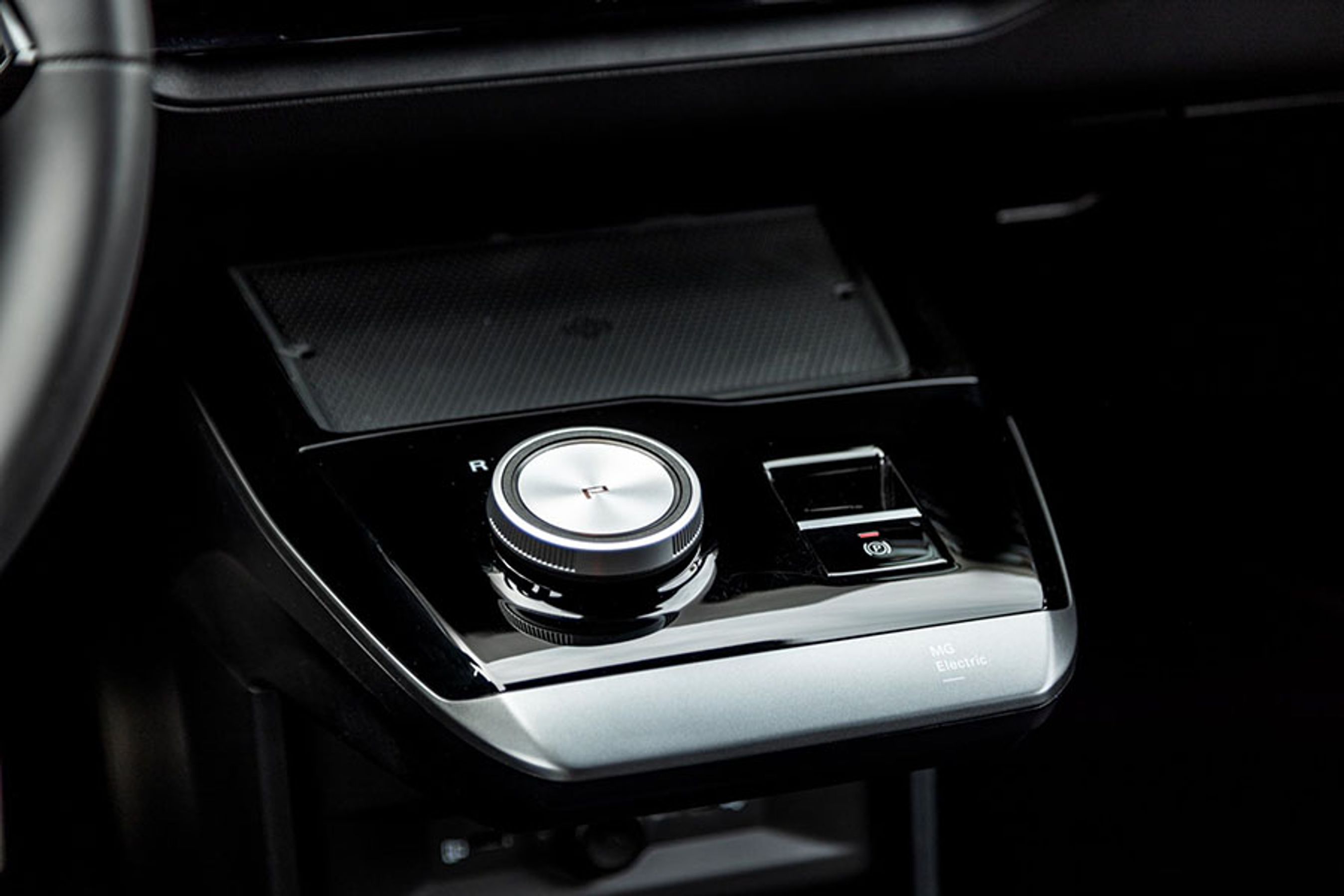 Mobilaflægningspladsen bag gearvælgeren er fortsat er meget glat og ikke har en kant, så mobilen risikerer at ryge på gulvet i et sving. 