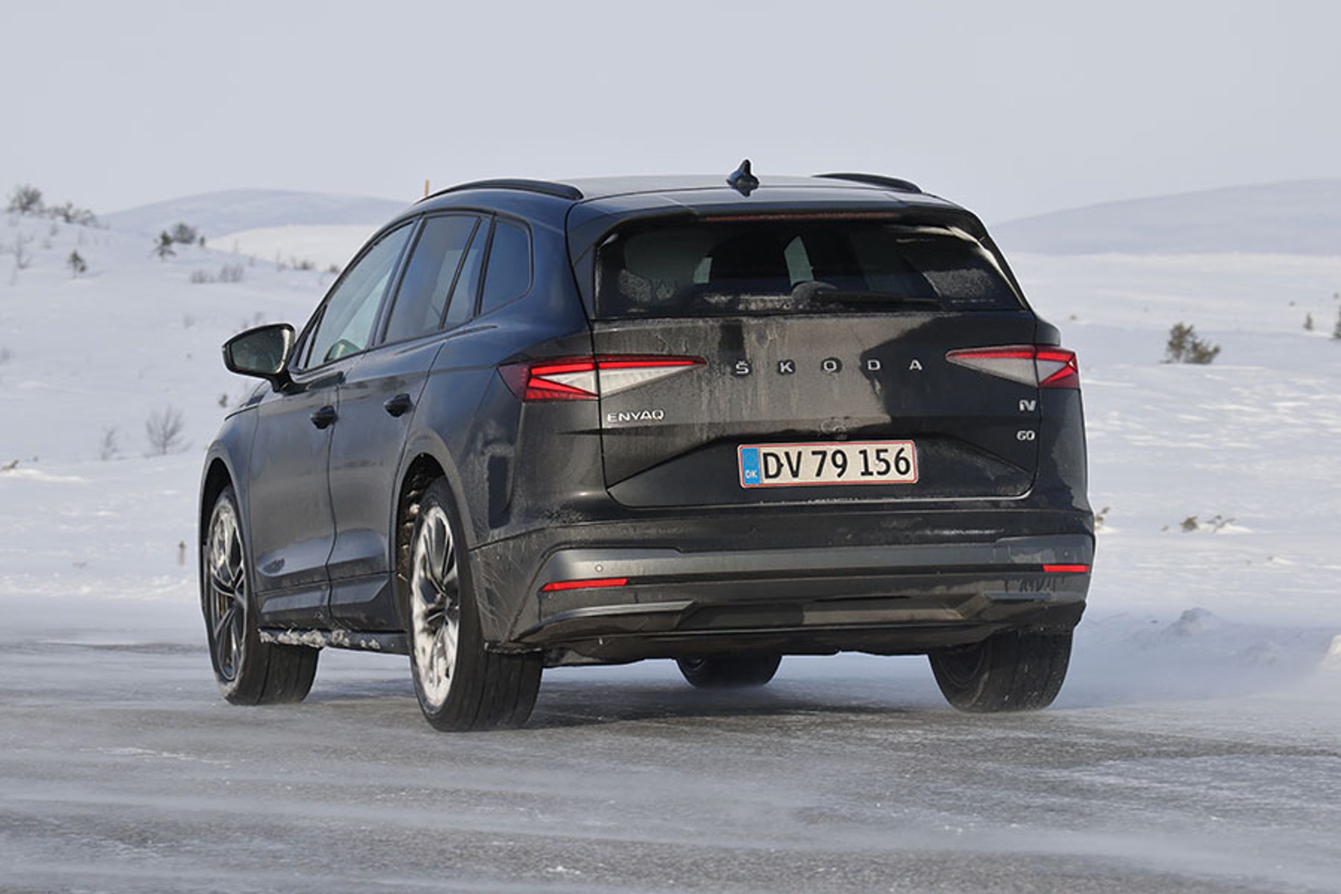 Sort Skoda Enyaq set bagfra, mens den kører på snedækket landevej