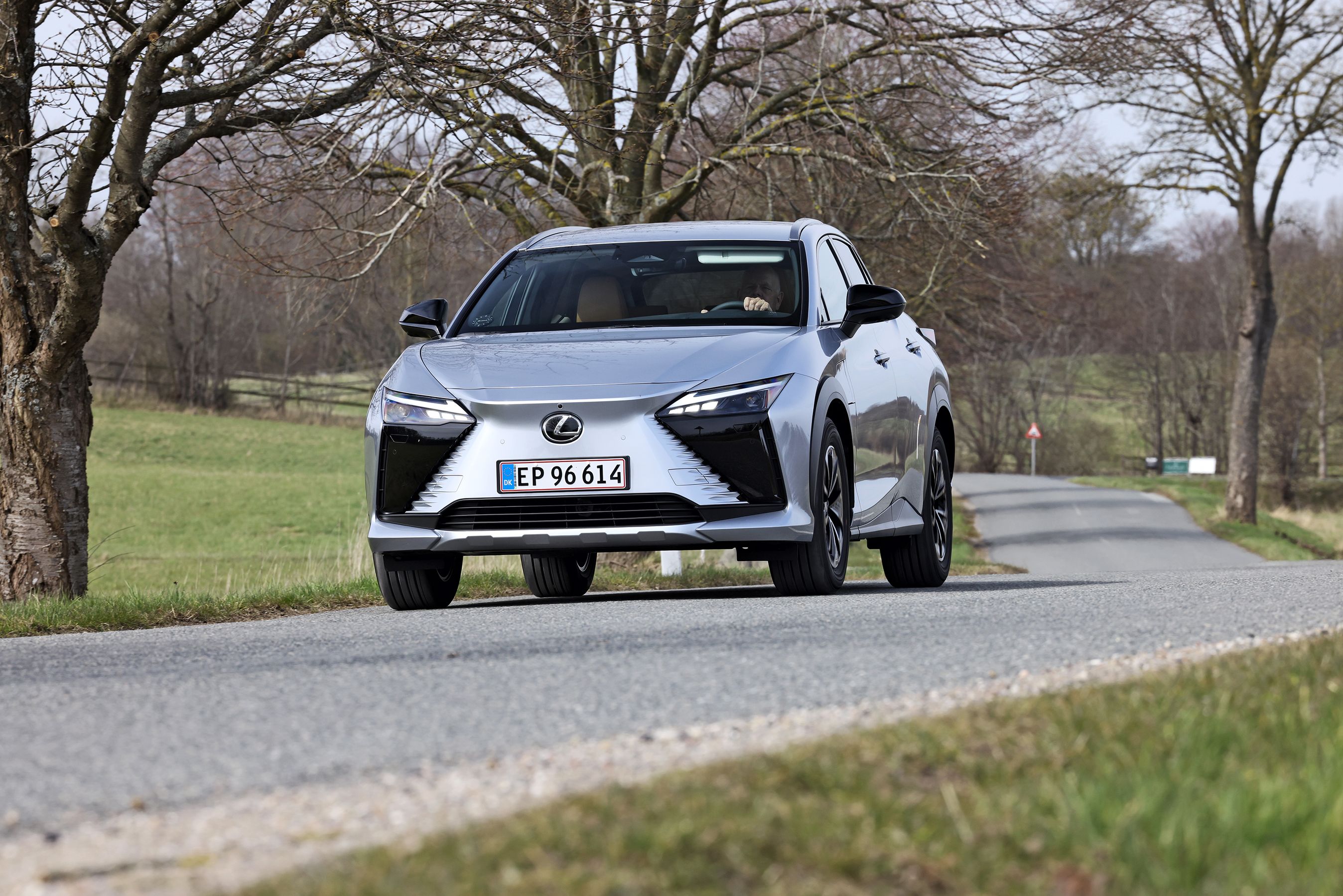 Lexus RZ set forfra, mens den kører på snoet landevej