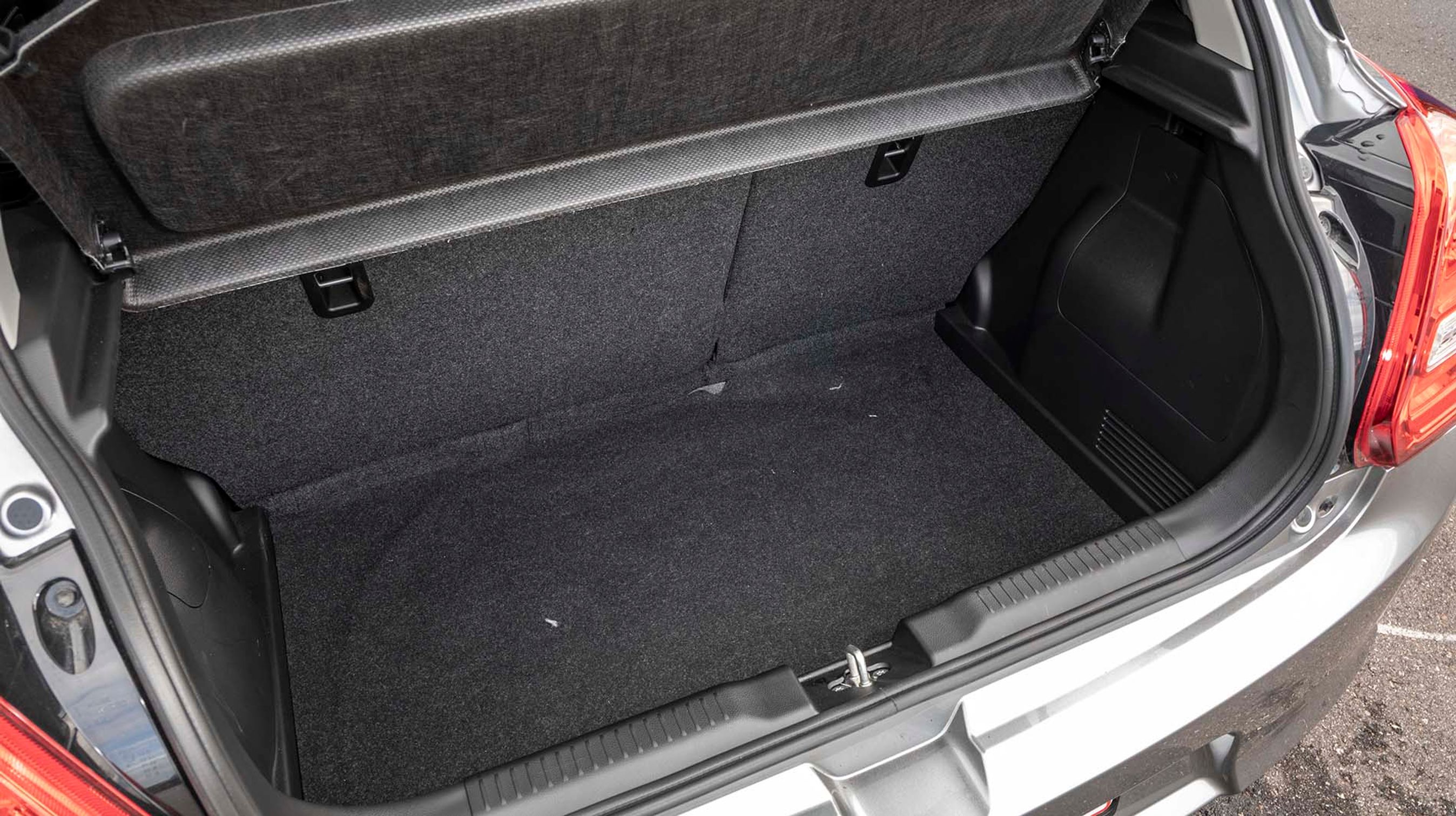 Bagagerummet i Swift er dybt og bredt, men byder også på en høj læssekant. Bagsædets ryglæn kan foldes forover, og længst nede under gulvet findes et lappekit.