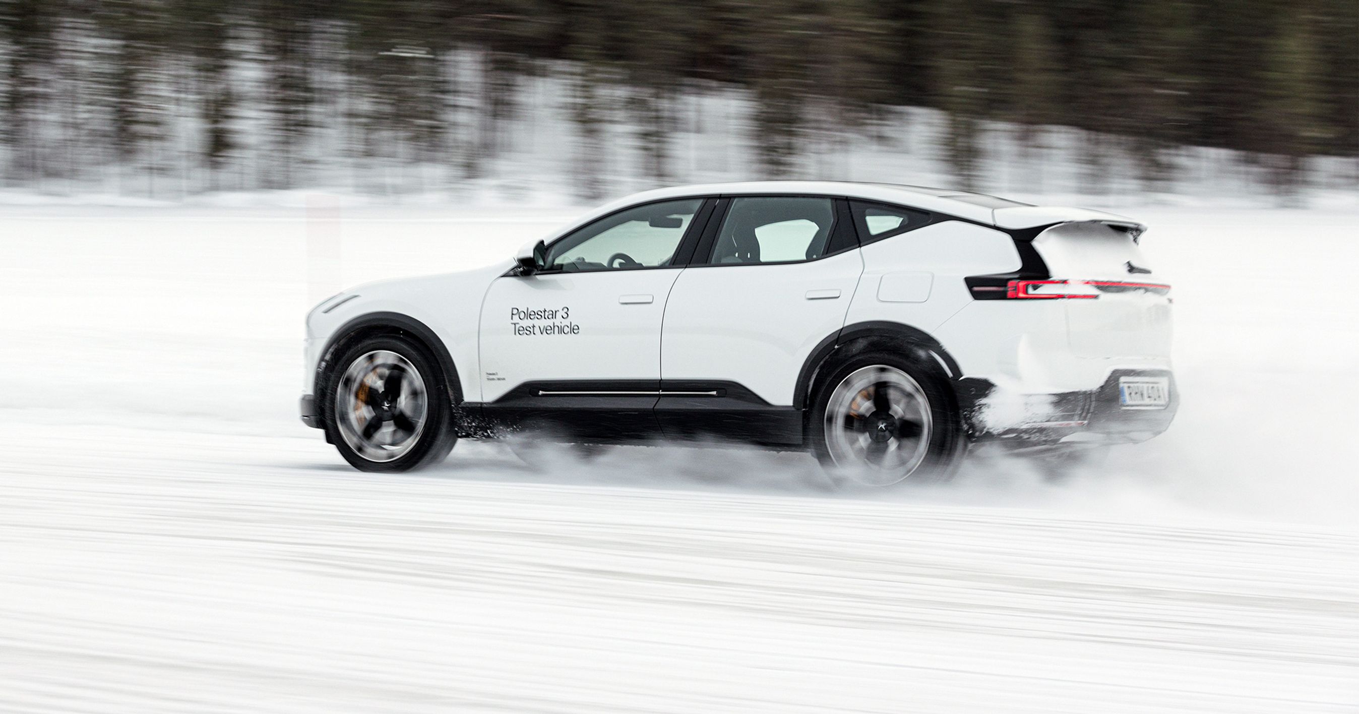 Hvid Polestar 3 bagfra kørende i sne.