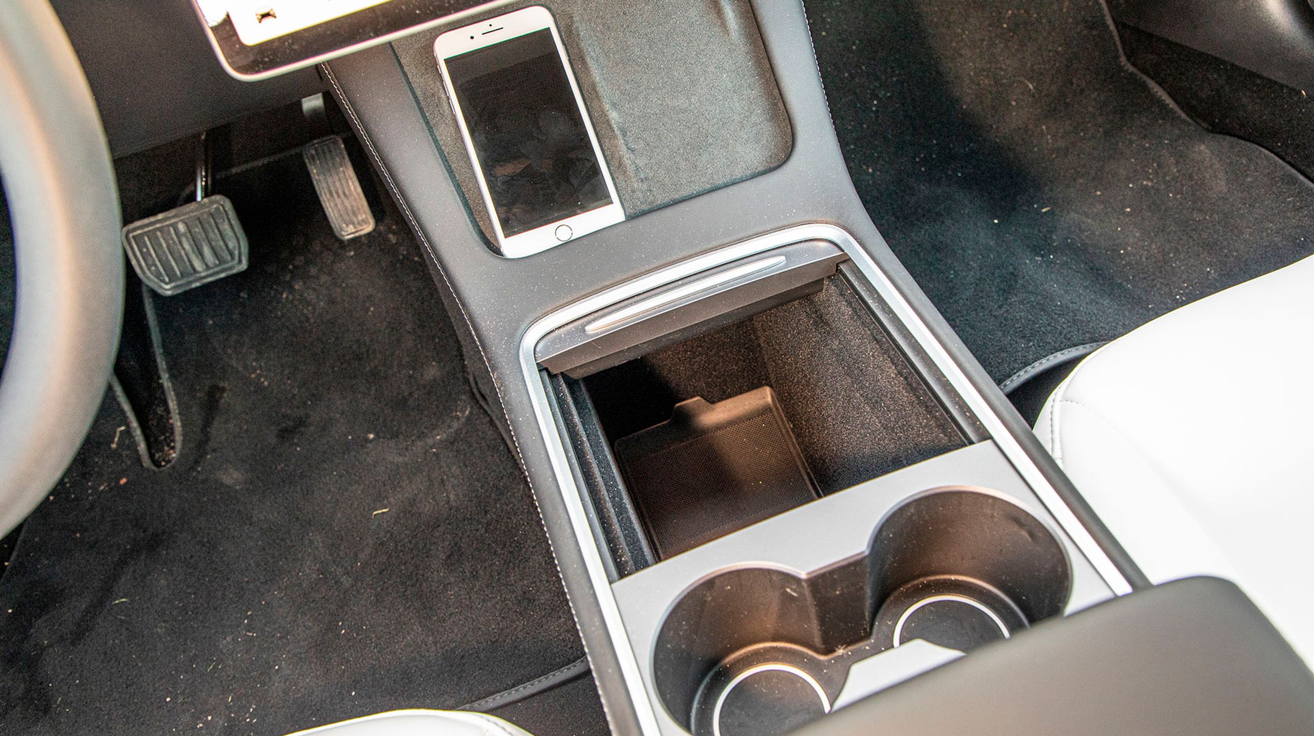 Man kan placere to telefoner på skrå under skærmen. Så lades de trådløst op. Der er ikke Apple CarPlay i en Tesla, i stedet styres tilsvarende funktioner direkte fra bilens opkobling. Talestyringen af bilen er utrolig effektiv.