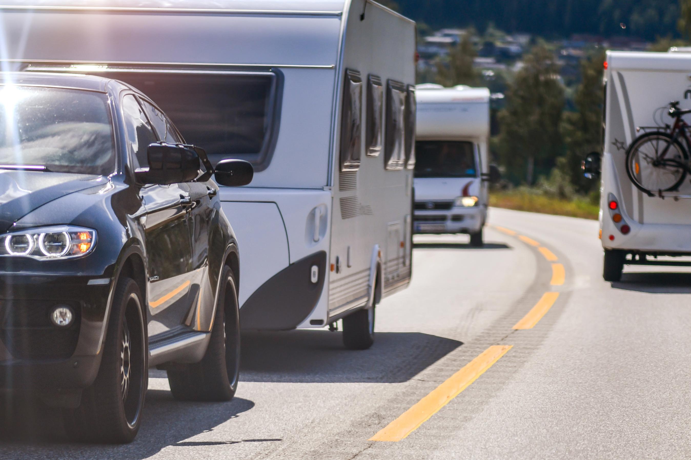 Bil med campingvogn på landevej