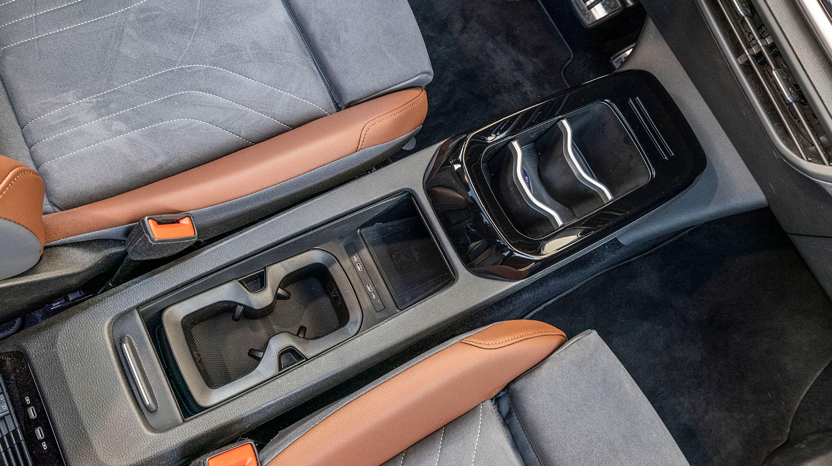 Mellem forsæderne er der plads til mobiltelefonen, som oplades trådløst, og der er gode kopholdere og god fralægningsplads. Et lille rullegardin kan køres hen over opbevaringsrummet.