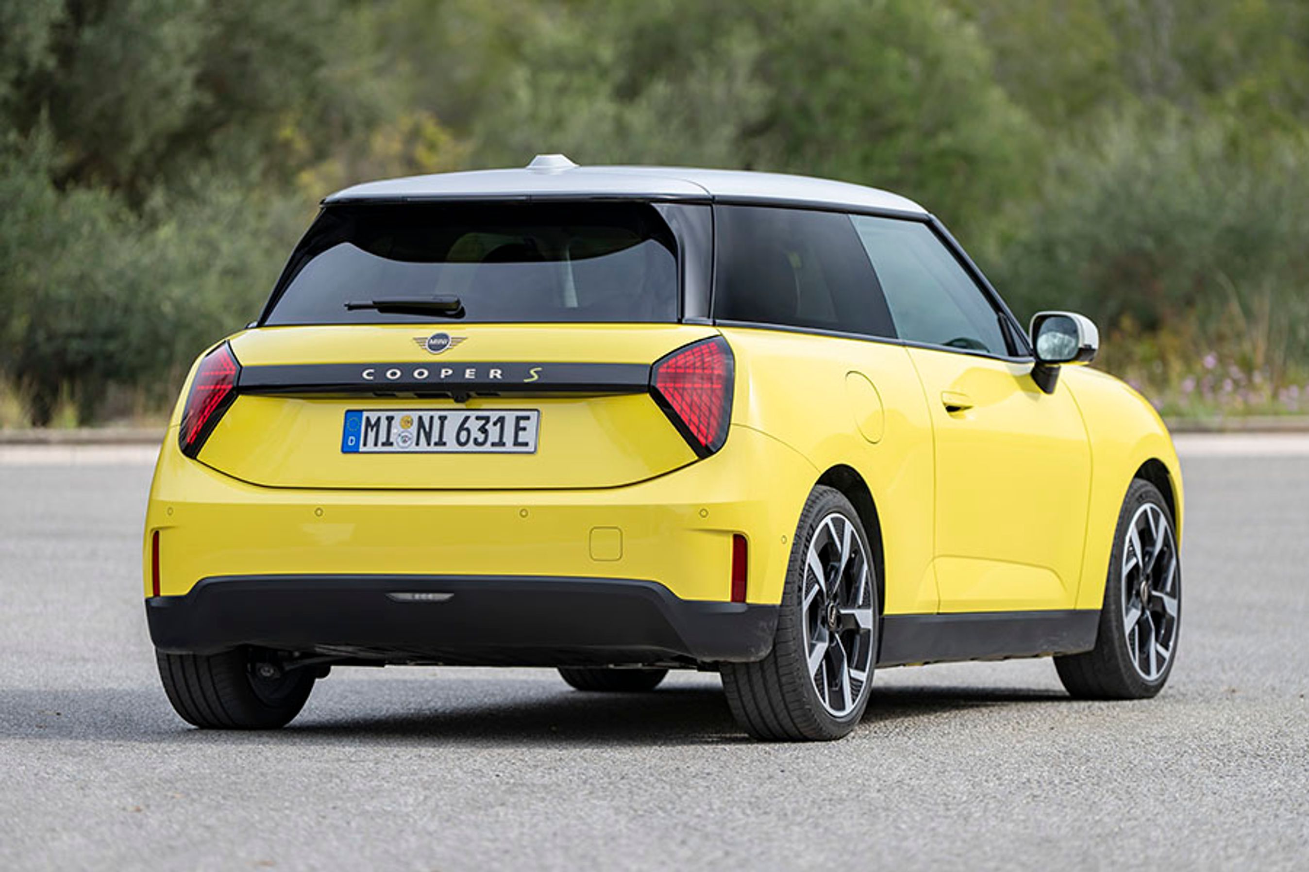 En gul Mini Cooper set bagfra, mens den holder stille