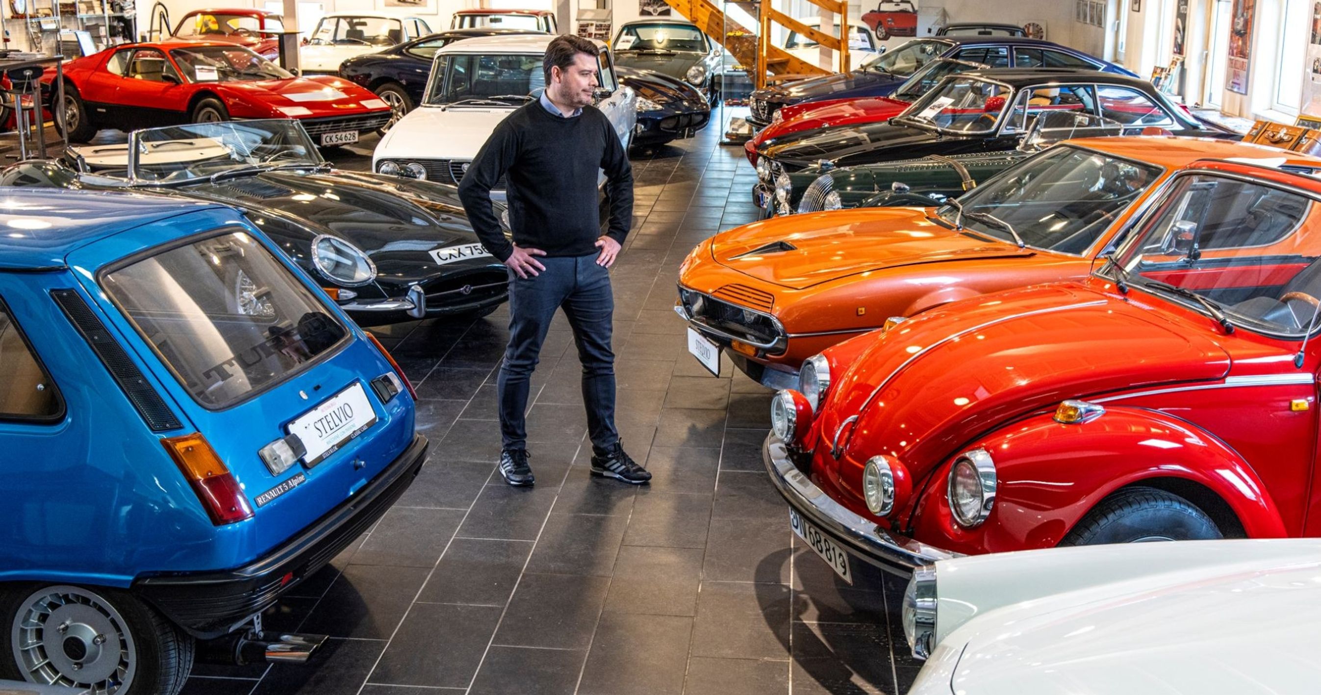 Mand i hal fyldt med klassiske biler