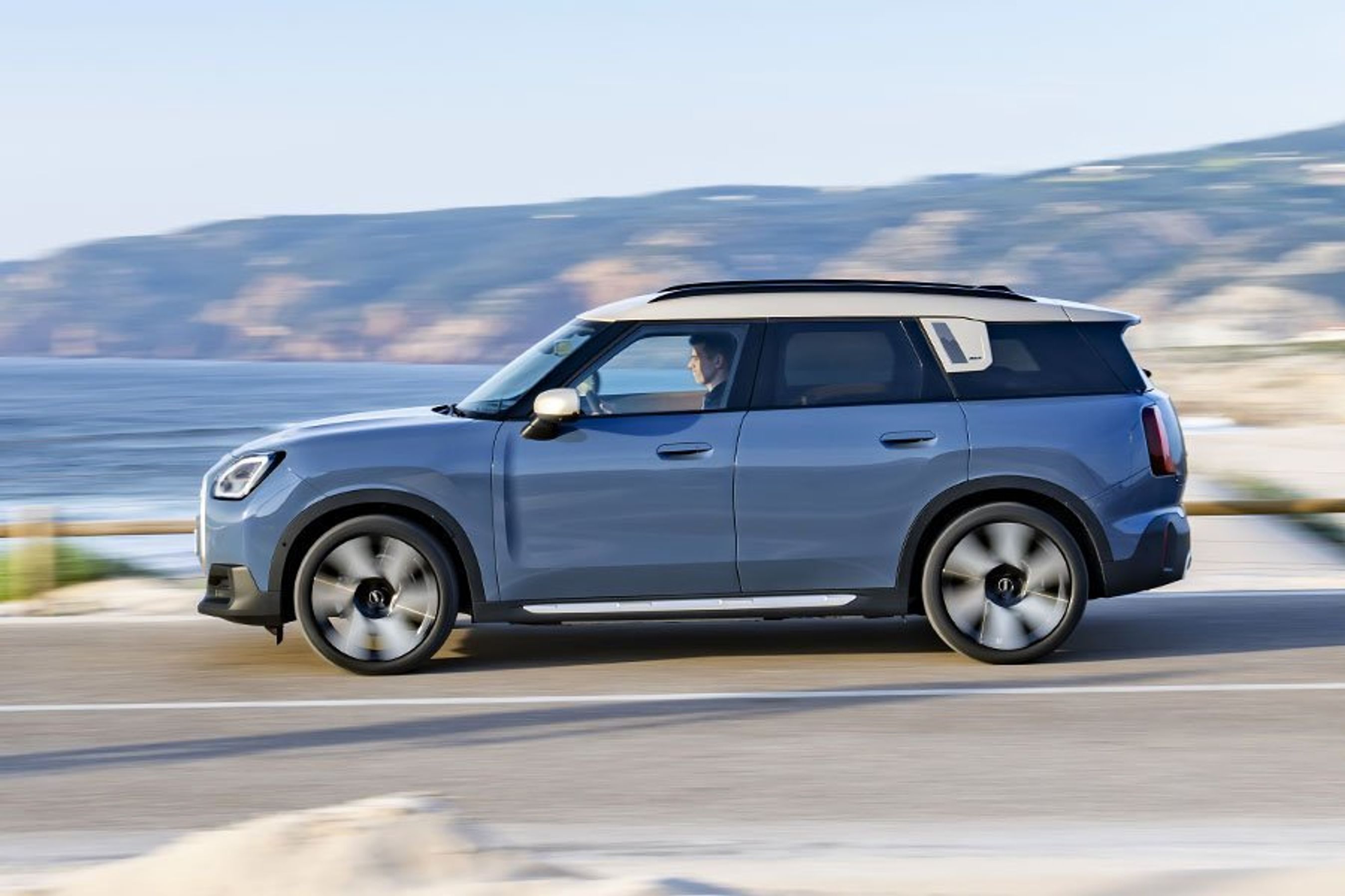 Mini Countryman set fra siden, mens den kører på en vej langs havet