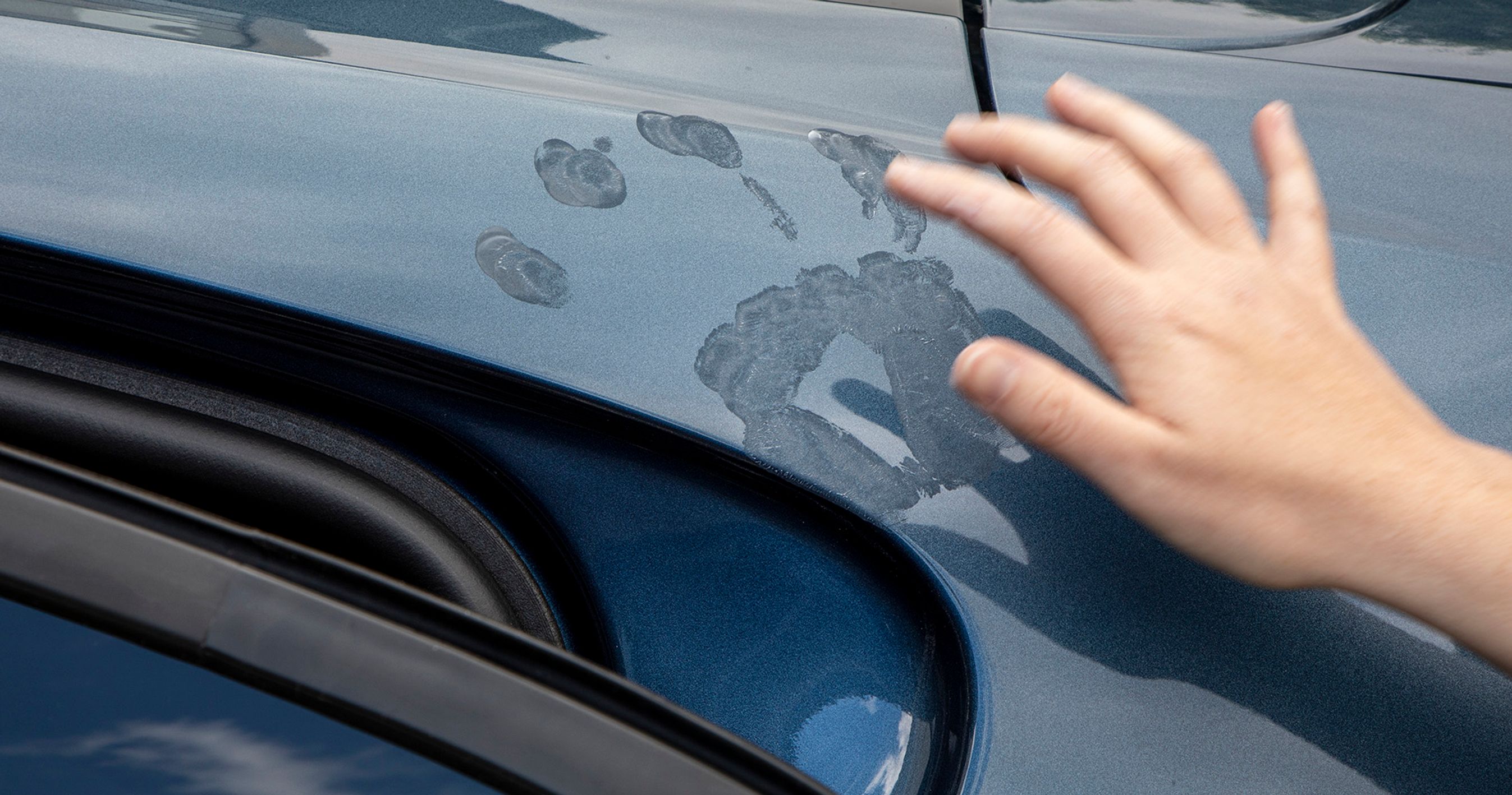 På billedet ser du solcreme på bilens lak efter hånden har hvilet på bilen. 