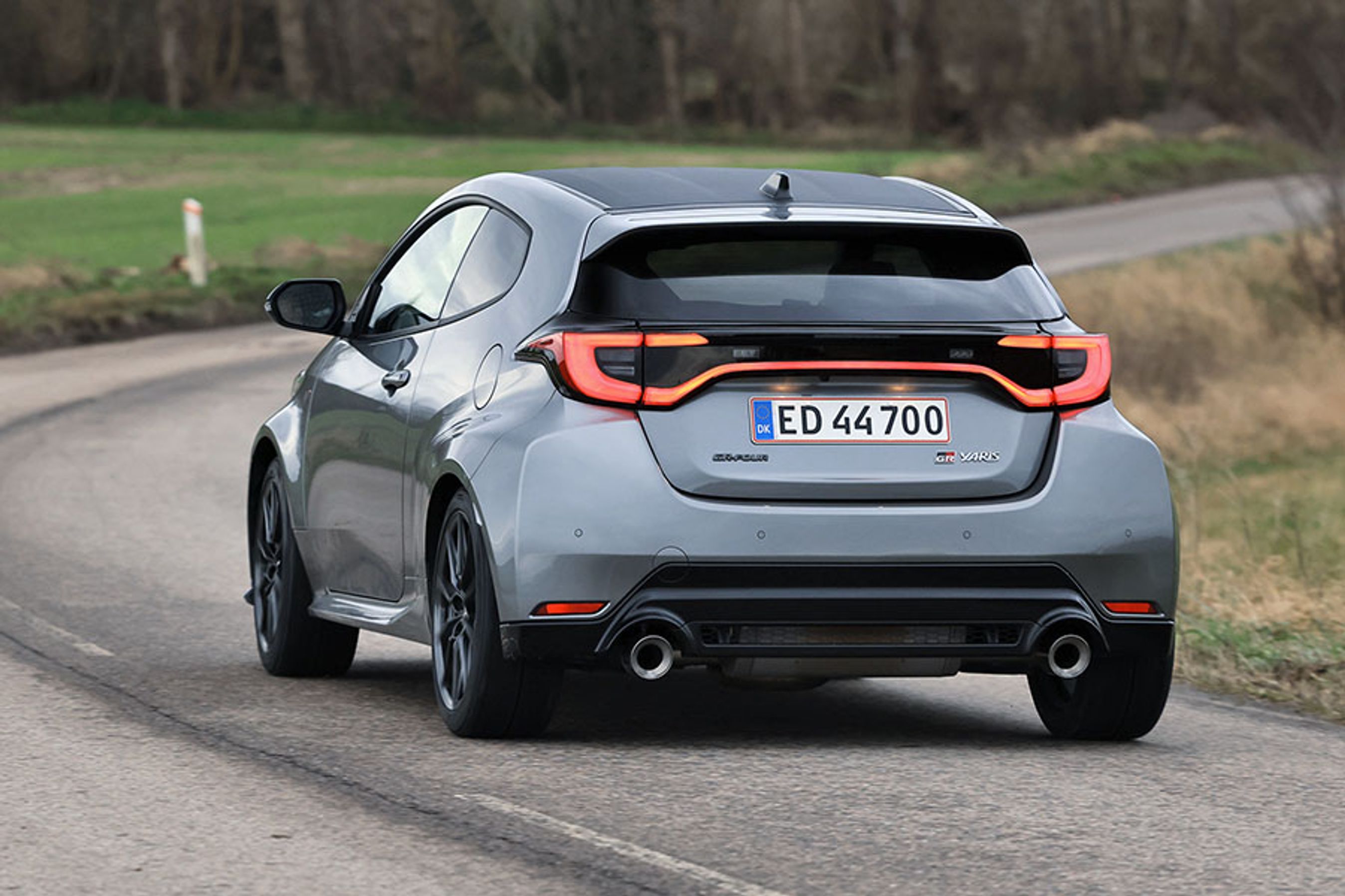 Toyota GR Yaris set bagfra, mens den kører ind i et sving på en landevej