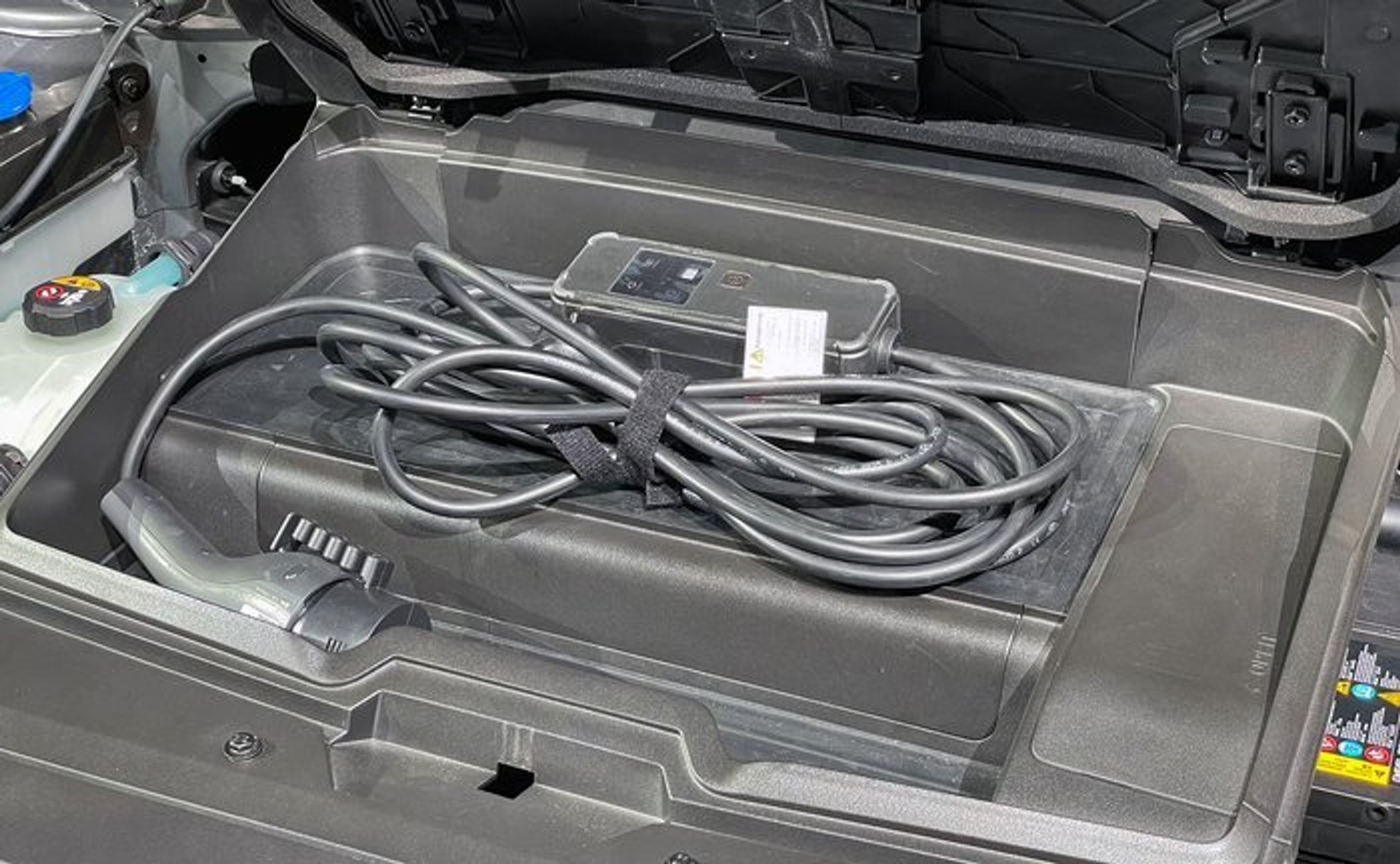 Forrest i bilen er der et ekstra bagagerum. Med firehjulstræk er det dog kun på ca. 20 liter - lige nok til et ladekabel og adapteren til strømudtag. Praktisk at det ikke ligger under bagagerummet, når det er fyldt med bagage.