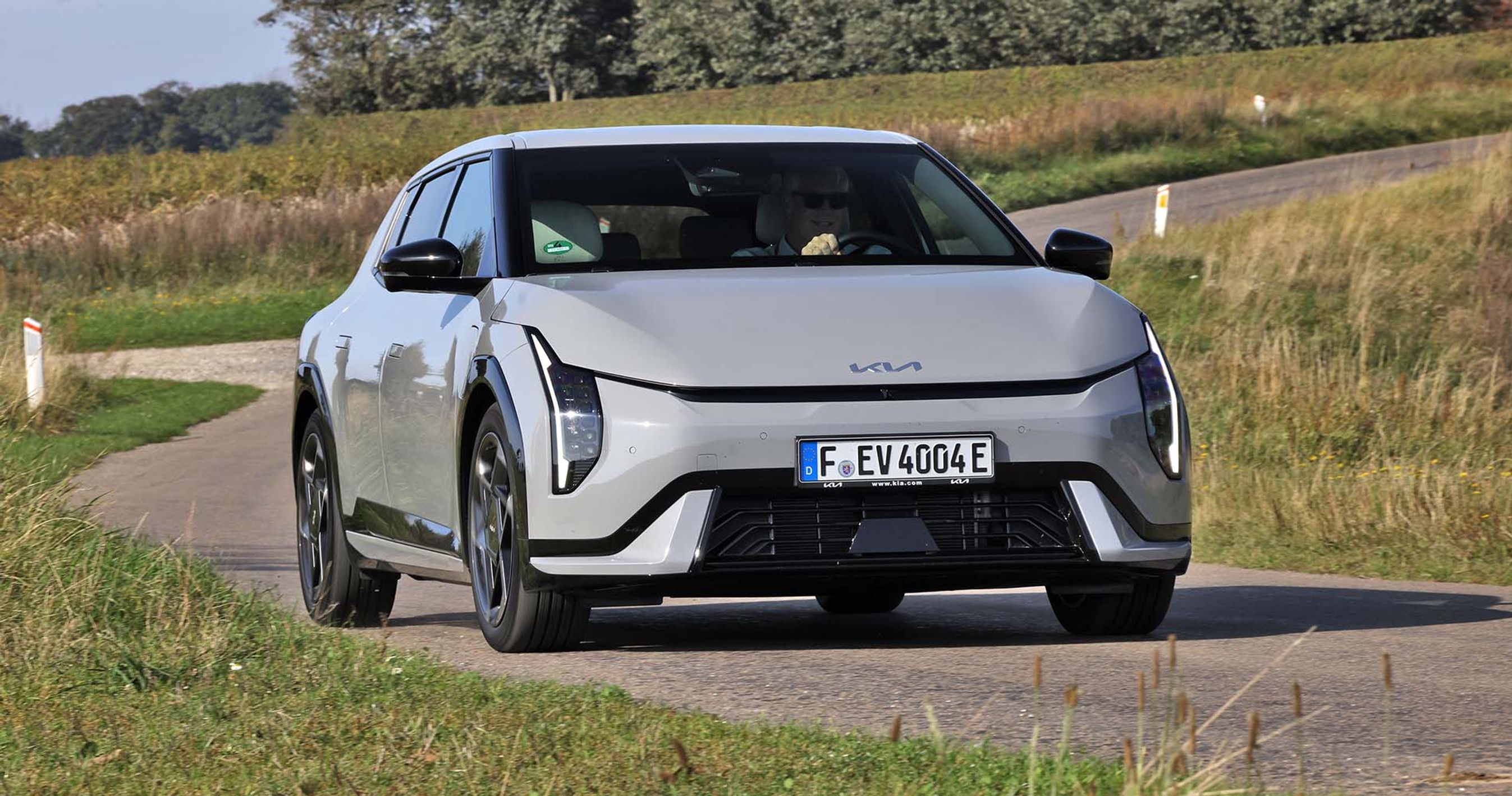 Kia EV4 set forfra, mens den kører på bugtet vej