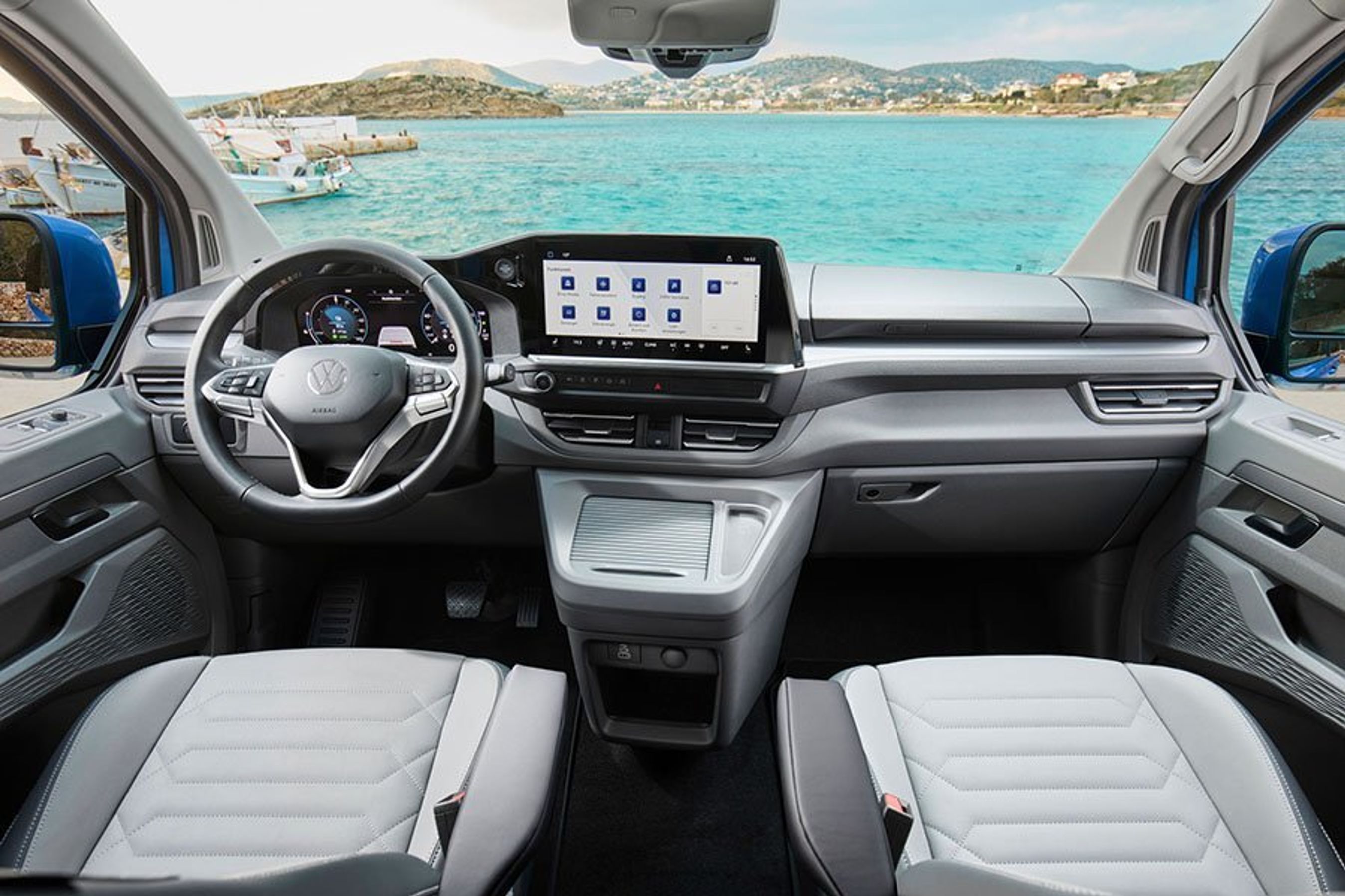 Førerpladsen i en VW e-Caravelle, der holder med udsigt til havet
