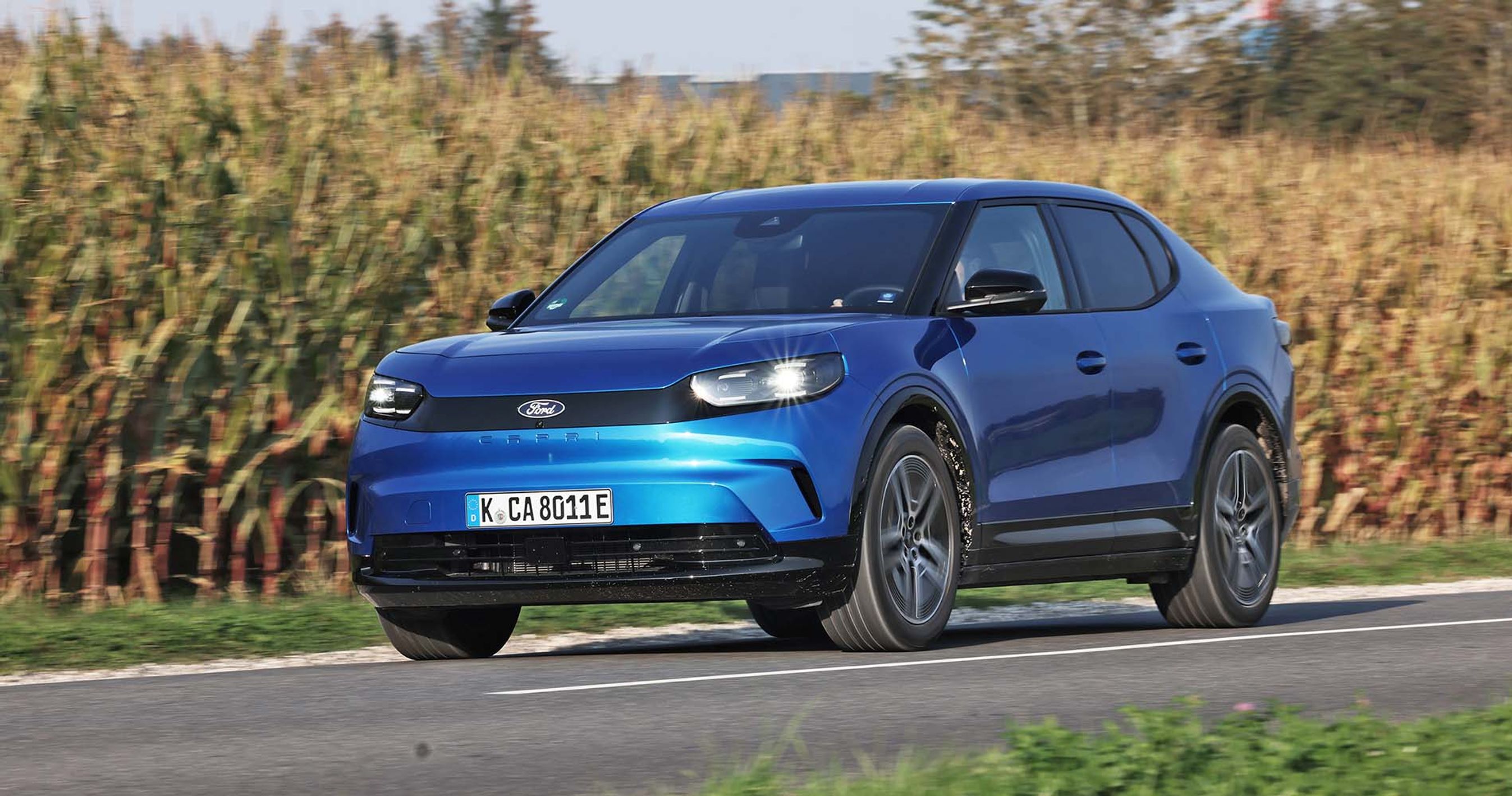 Blå Ford Capri kører langs mark