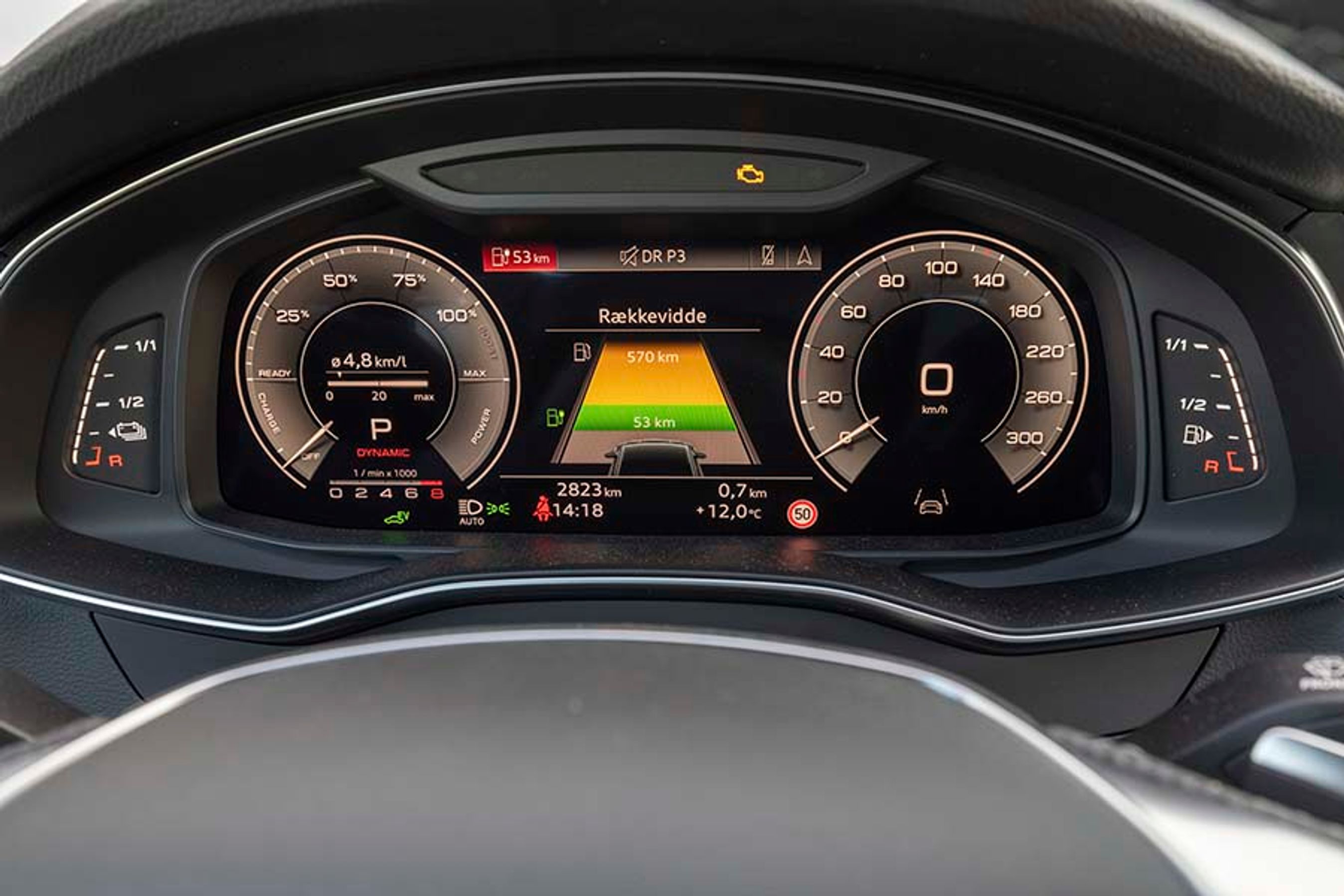 I midten af det store display i instrumenthuset ser man grafisk, hvordan den samlede rækkevidde er opdelt i et grønt felt, der viser rækkevidden på el, og et gult felt, der viser rækkevidden på benzin.