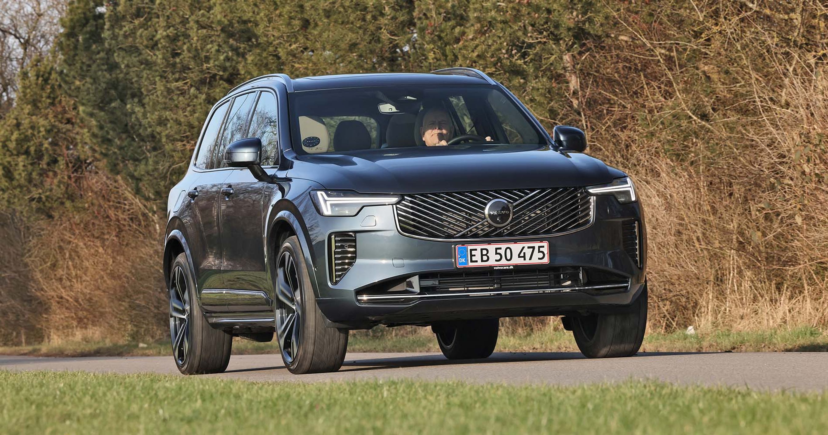 Volvo XC90 set forfra kører på landevej med buske i baggrunden