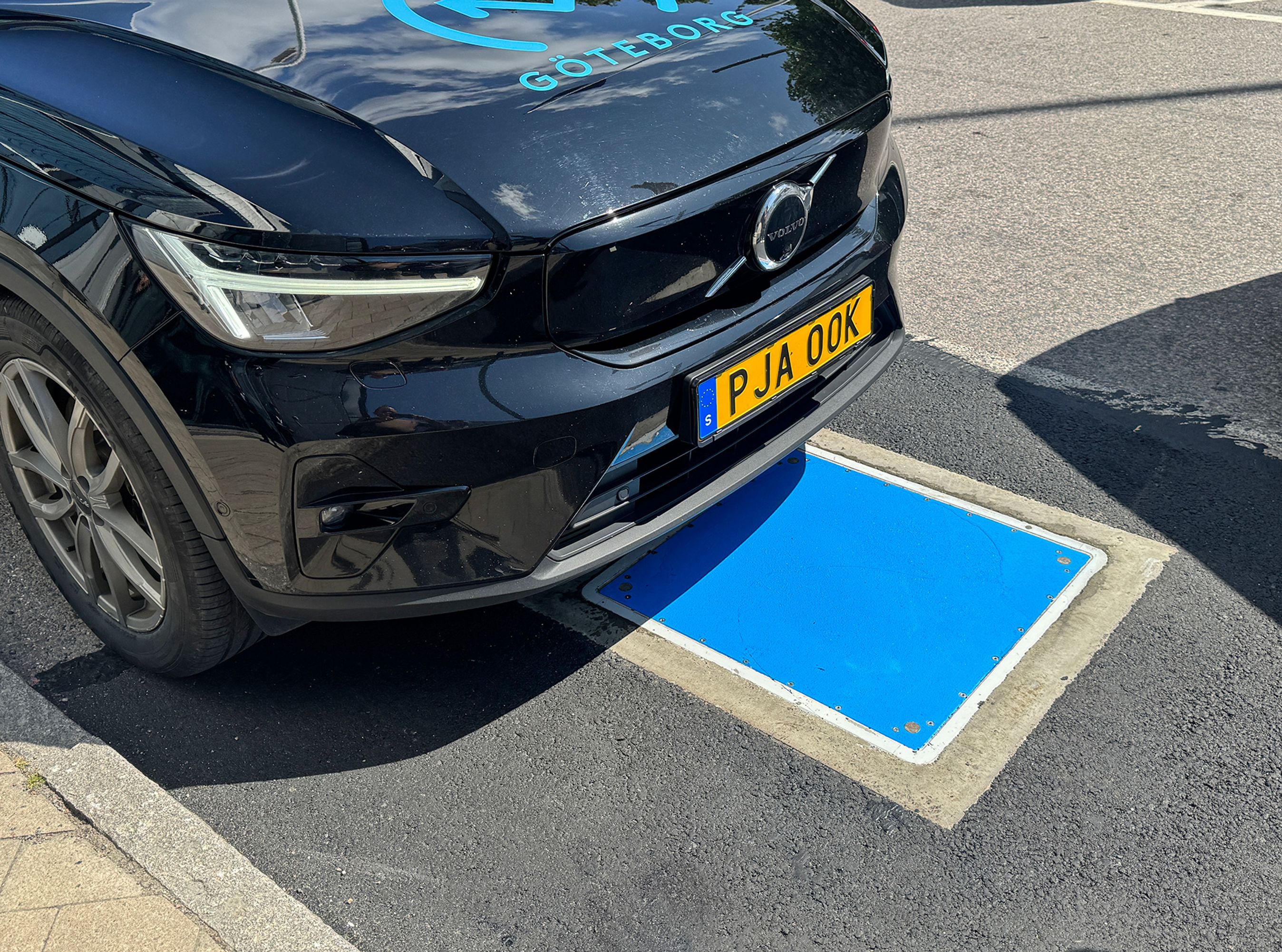 Snuden af Volvo over en blå plade i asfalten.