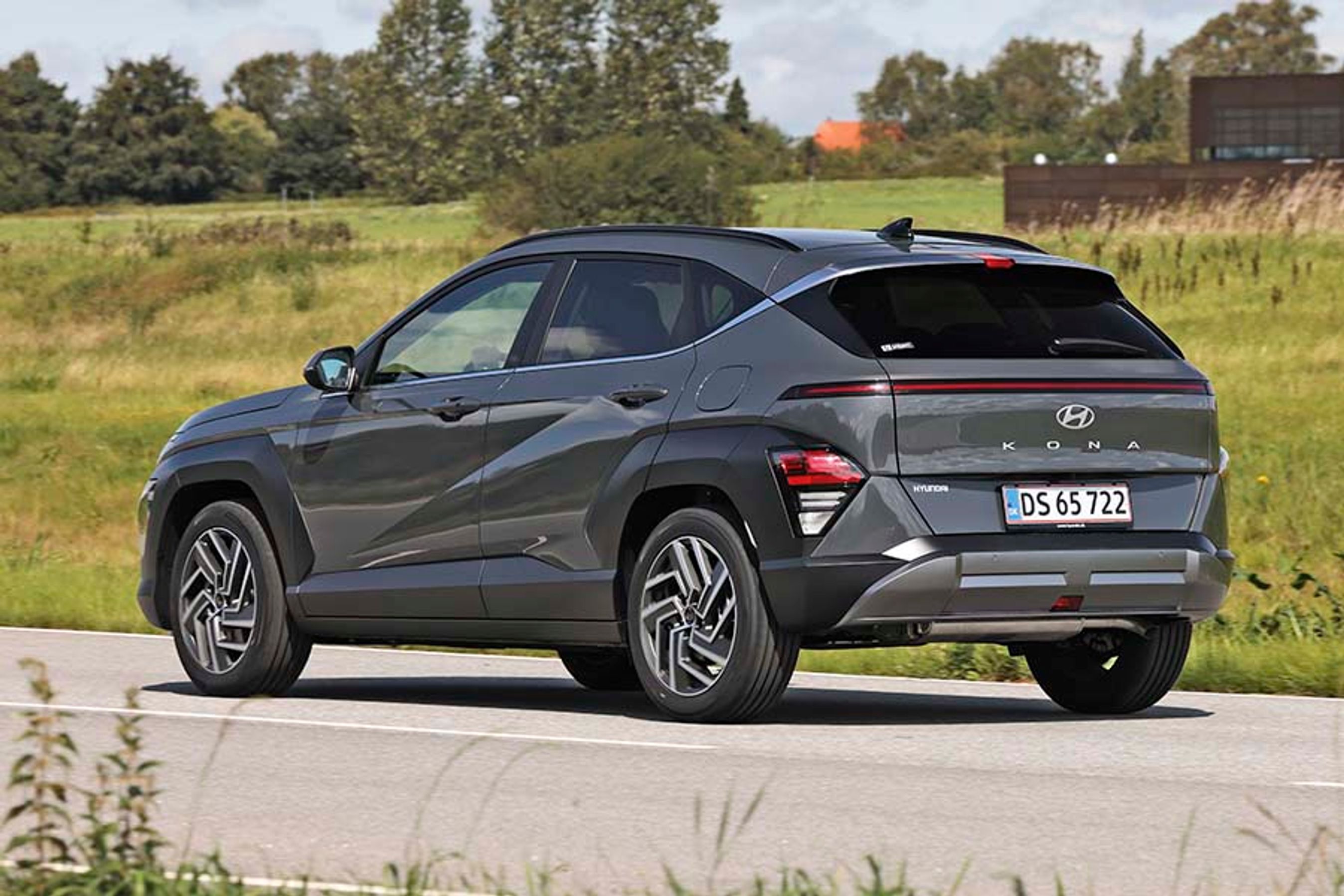 Hyundai Kona set bagfra, mens den kører på en landevej.
