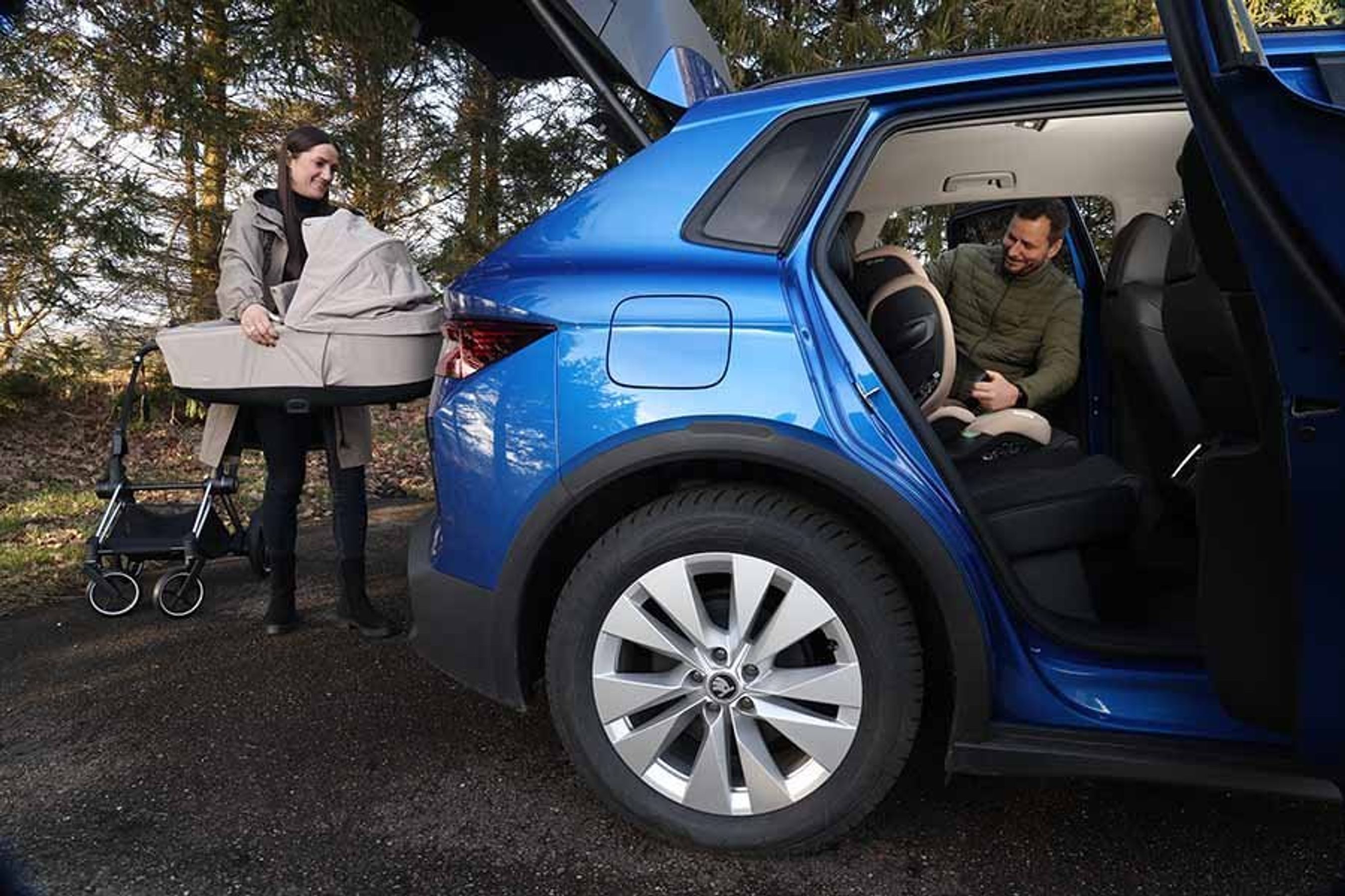 Forældre monterer autostol og barnevogn i en elbil