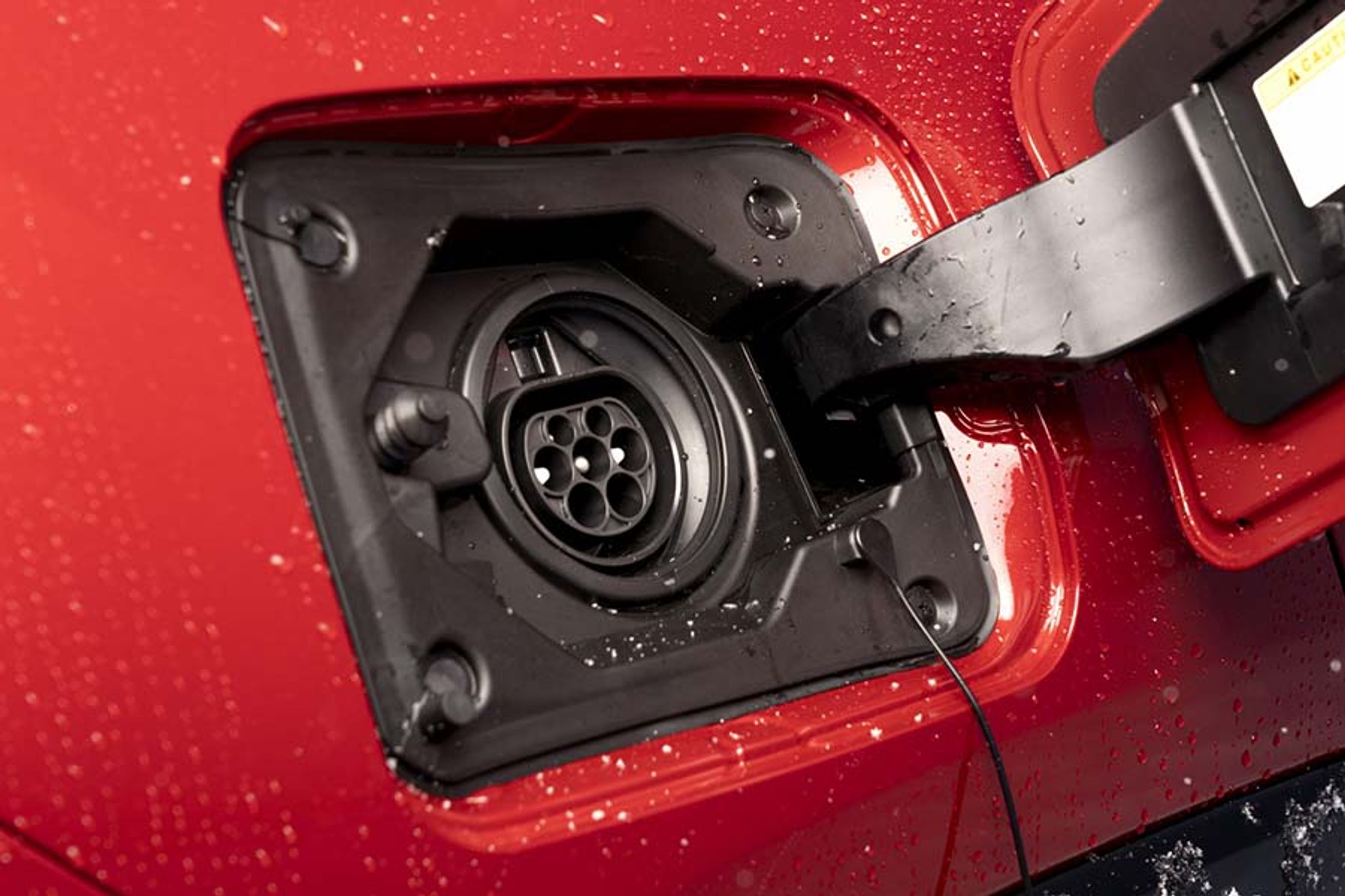 Ladestikket er placeret ved højre baghjul. Man kan kun lade med strøm fra en enkelt fase, og det giver de fleste steder maksimalt 3,7 kW. Dermed tager det fem timer at lade bilen helt op.