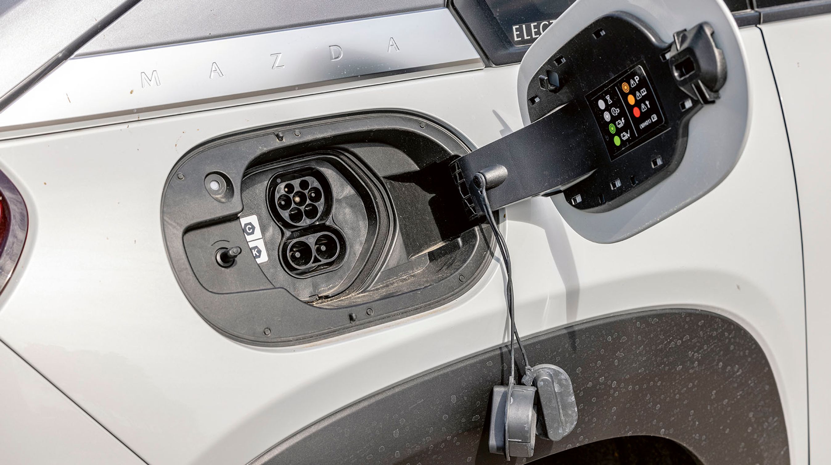 Ladestikket er placeret ved højre baghjul og er et CCS-Combo-stik. Der er kun en enkelt fase til hjemmeladning, og det medfører lange ladetider. De to plastpropper skal fjernes, når man lader.