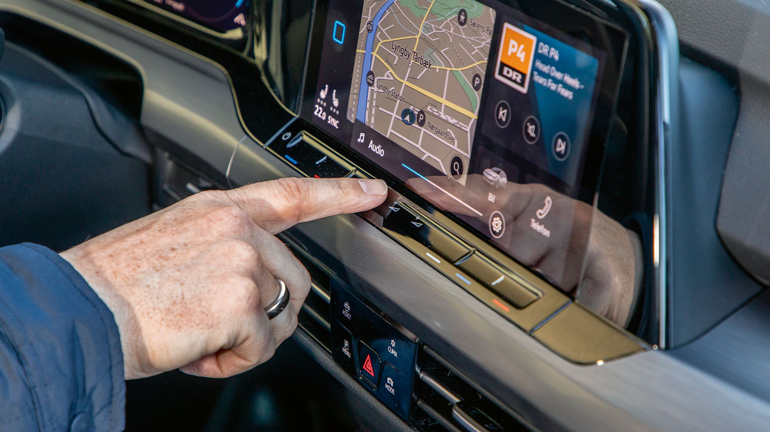 Under skærmen er der et panel, hvor man med let finger-berøring kan justere lyden eller indstille varmen i sæderne.