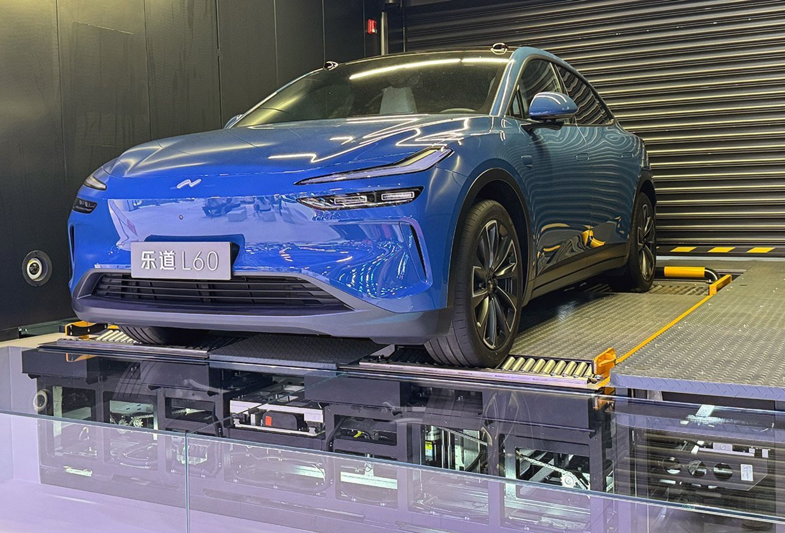 Blå bil forfra på batteriskifte-enhed.