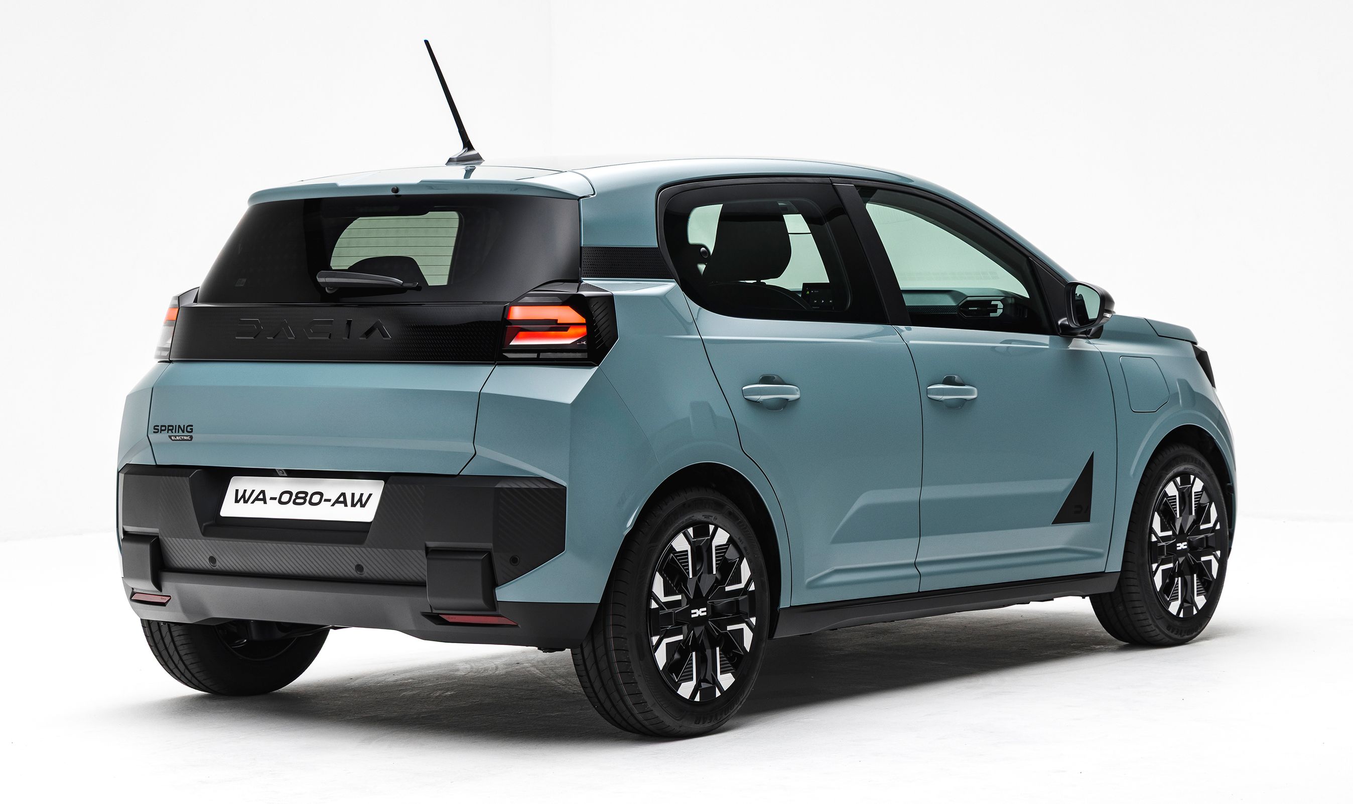 Blålig Dacia Spring bagfra i studie.