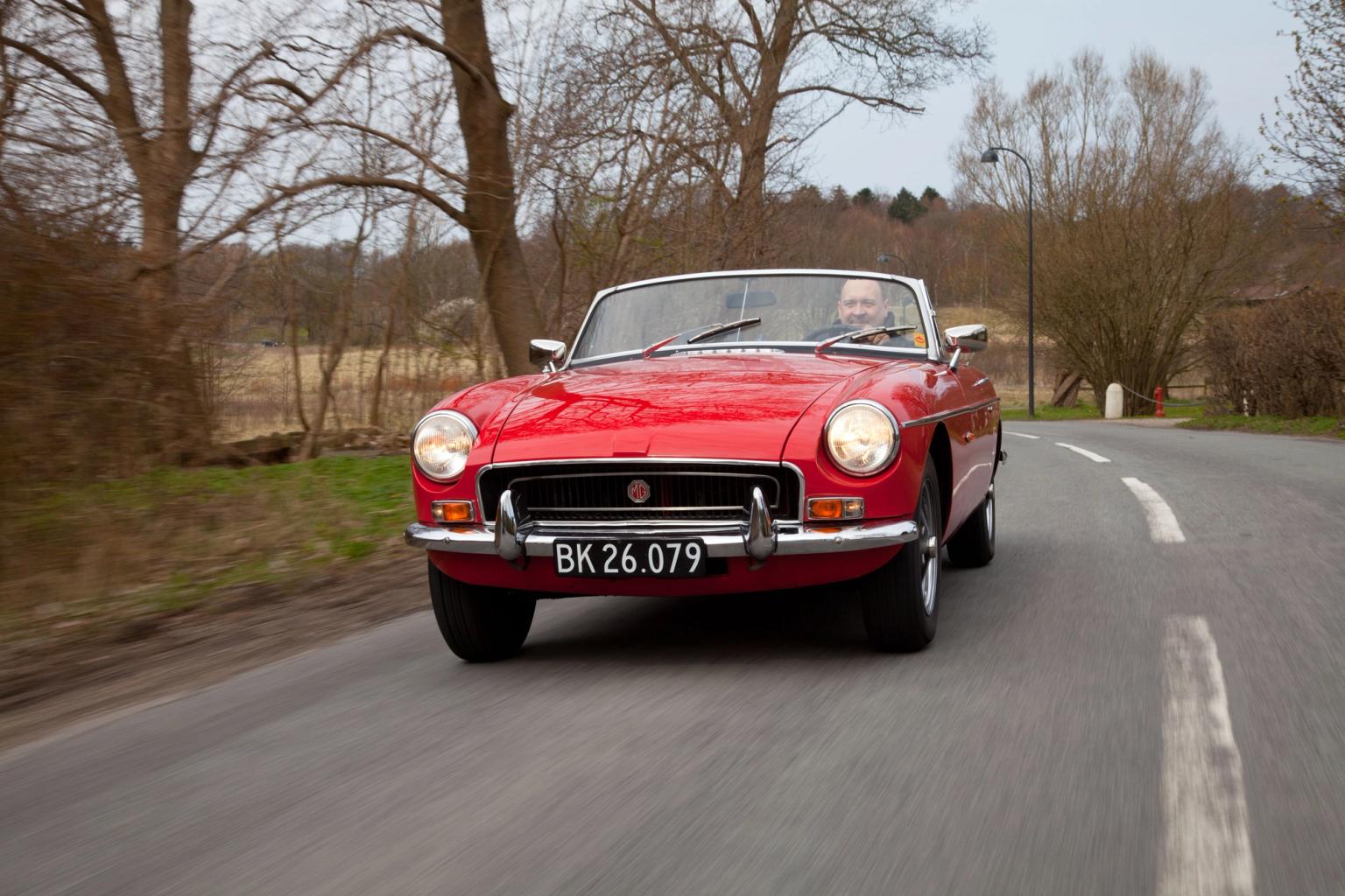 Bilist kører i en rød veteranbil