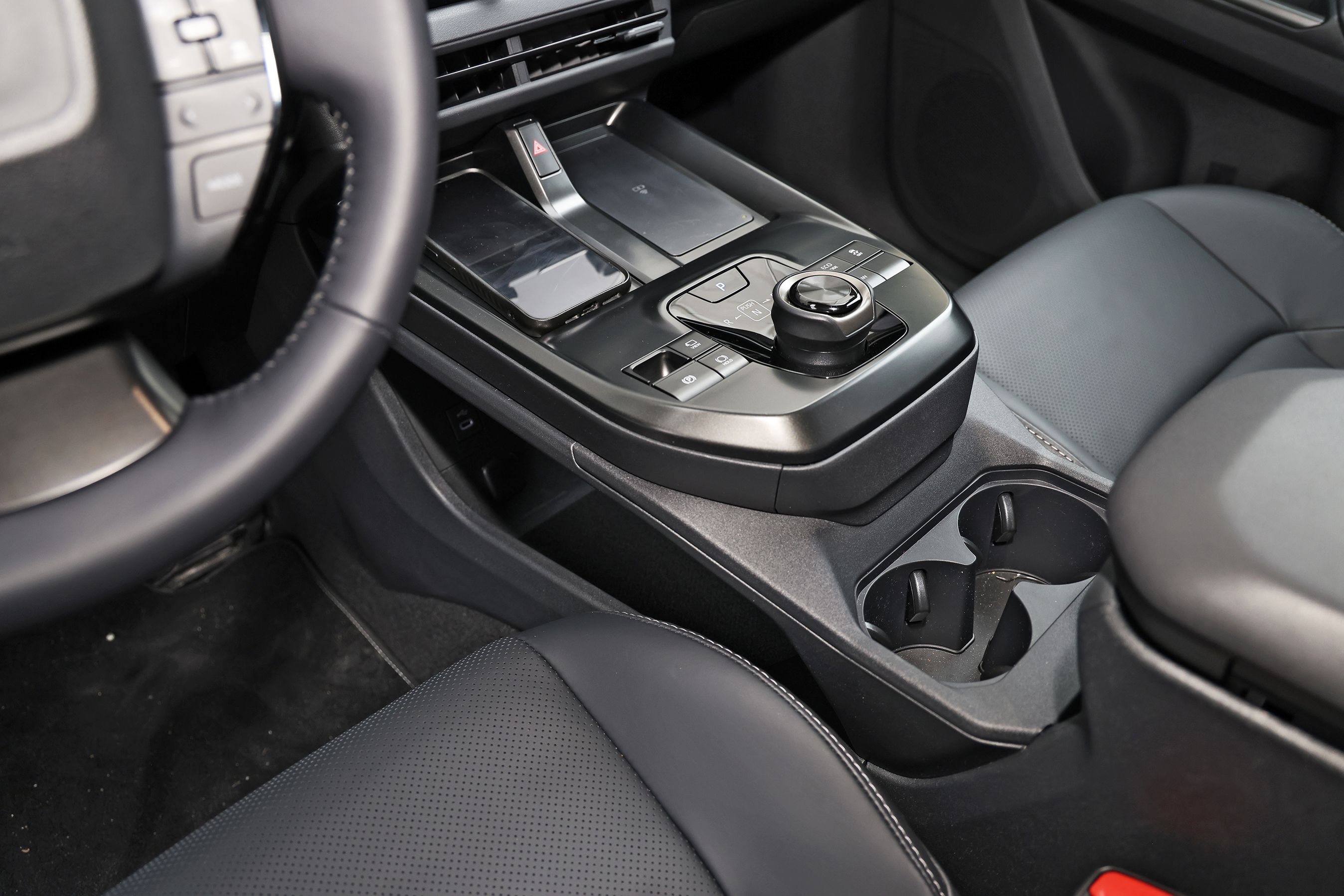 Konsol med gearvælger, mobilopladere og kopholdere i en Toyota bZ4X