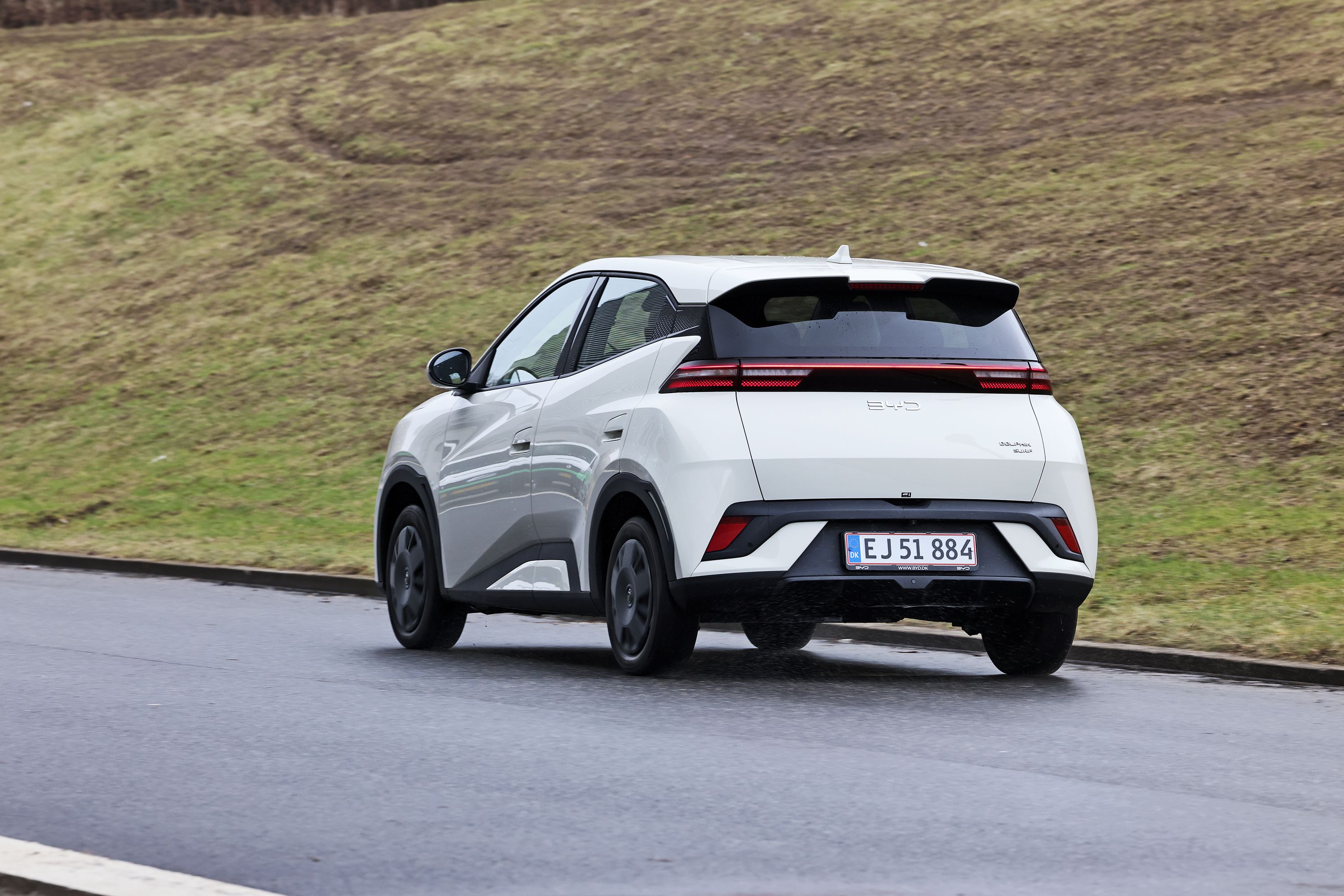 BYD Dolphin Surf 2026 set bagfra på asfaltvej med græs i baggrunden. 