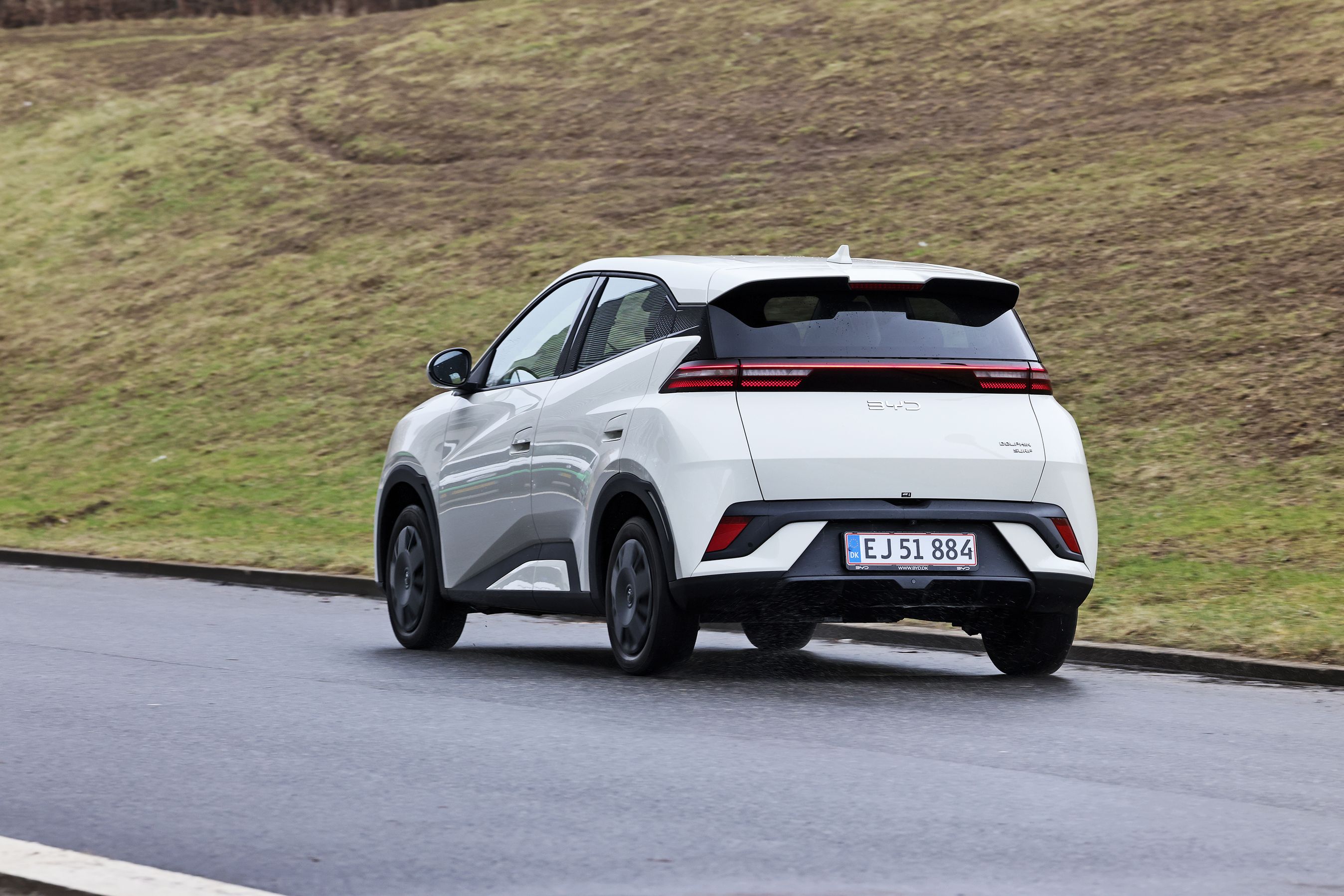 BYD Dolphin Surf 2026 set bagfra på asfaltvej med græs i baggrunden.